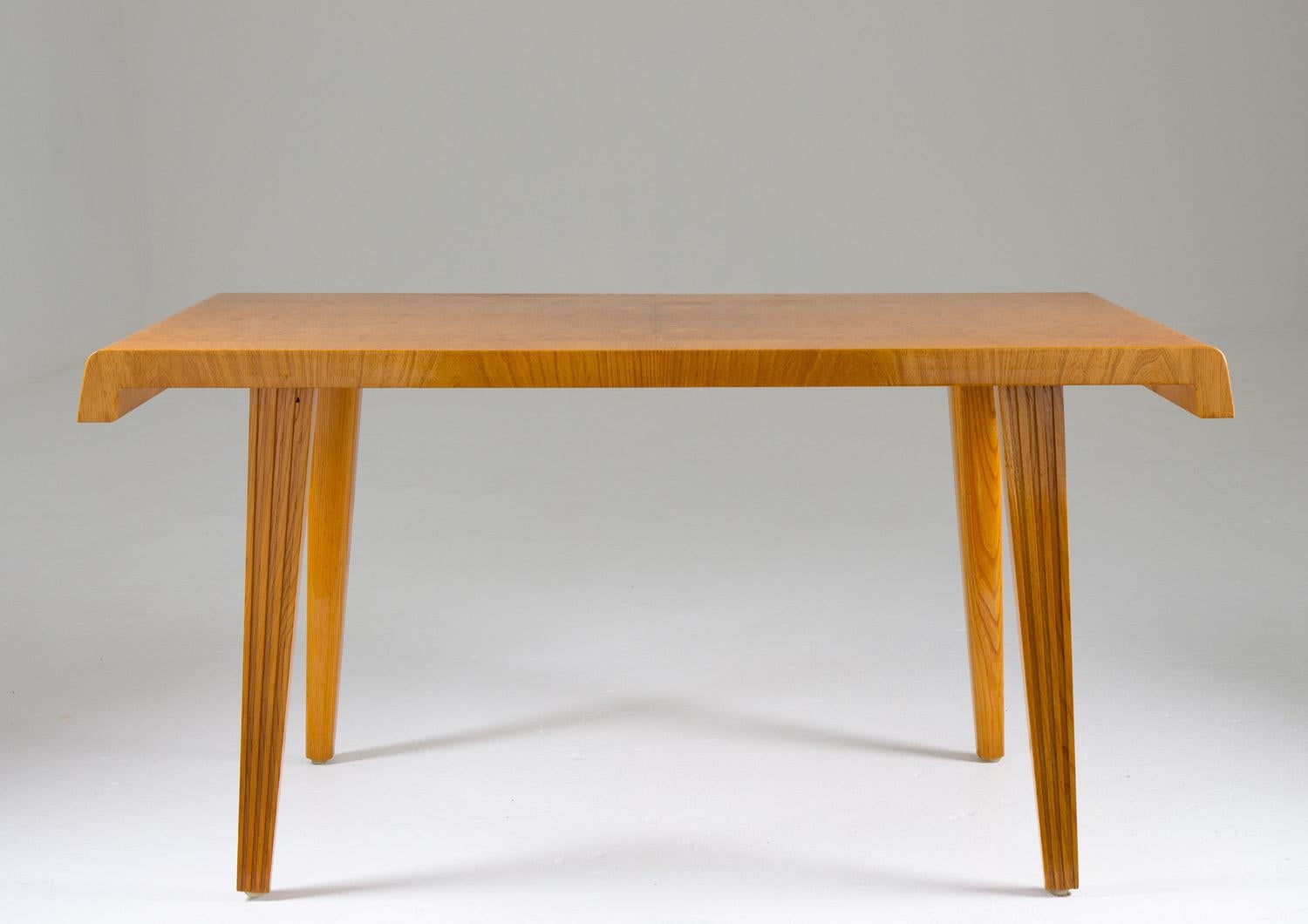Add a touch of Scandinavian style to your home with this beautiful coffee or side table, made of elm and elm root veneer. This table is a superb example of the great designs that emerged during the Swedish modern era, and it is sure to become a