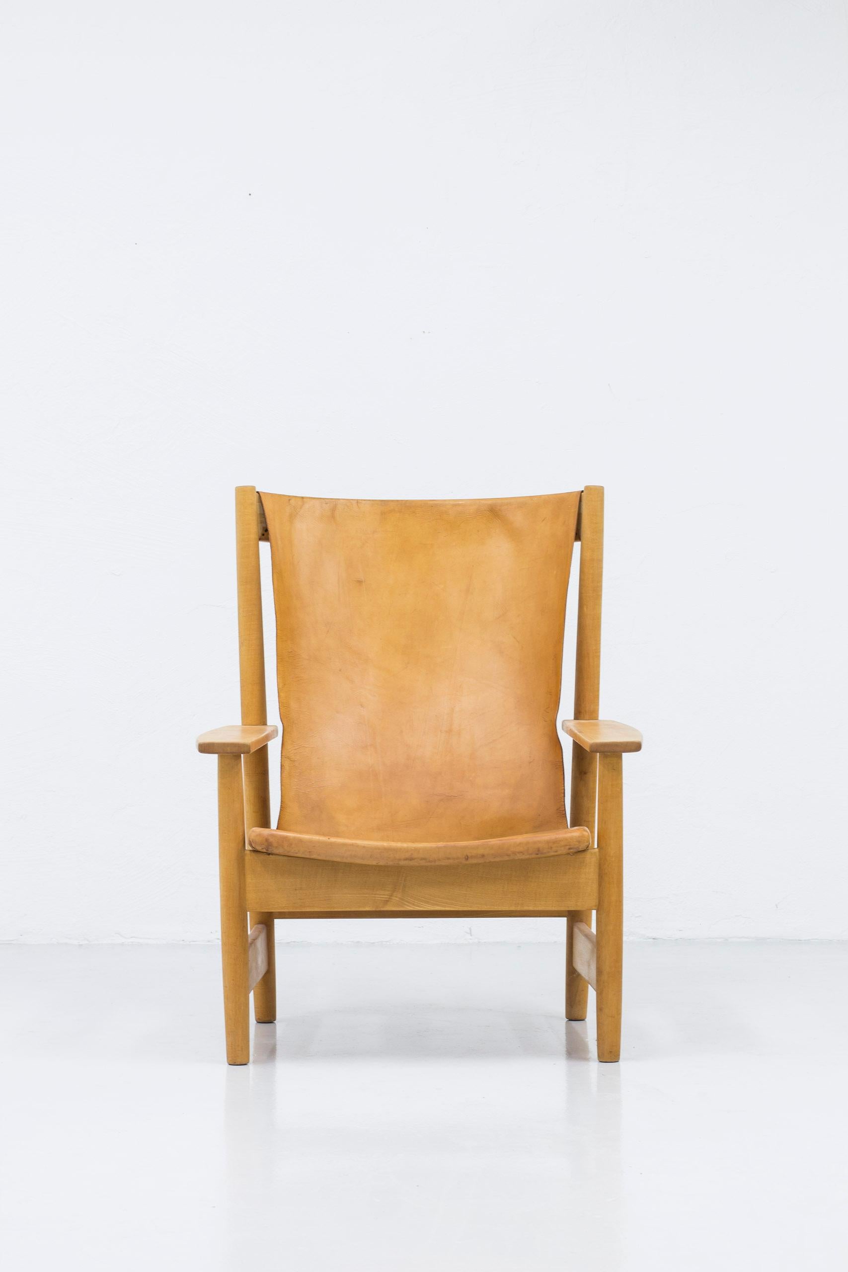 Large and powerful high back lounge chair from the Swedish Modern era. Made from solid beech wood with natural leather that has aged into a beautiful cognac color. Made in Sweden during the 1950s. Very good vintage condition with age related wear