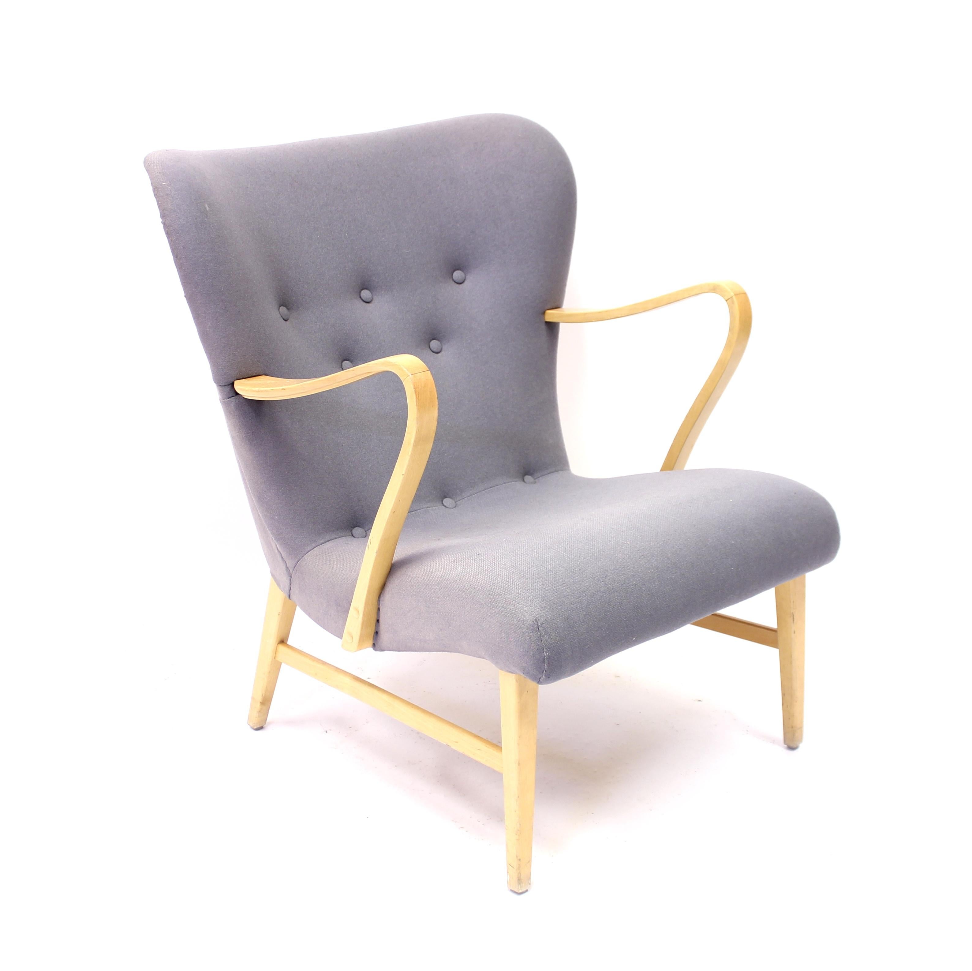 Midcentury Swedish modern curved easy chair, attributed to Swedish designer Erik Bertil Karlén, with a velvet like grey/blue upholstery. Legs and armrests of birch. The chair has a very light expression due to the quite thin legs and armrest. Good