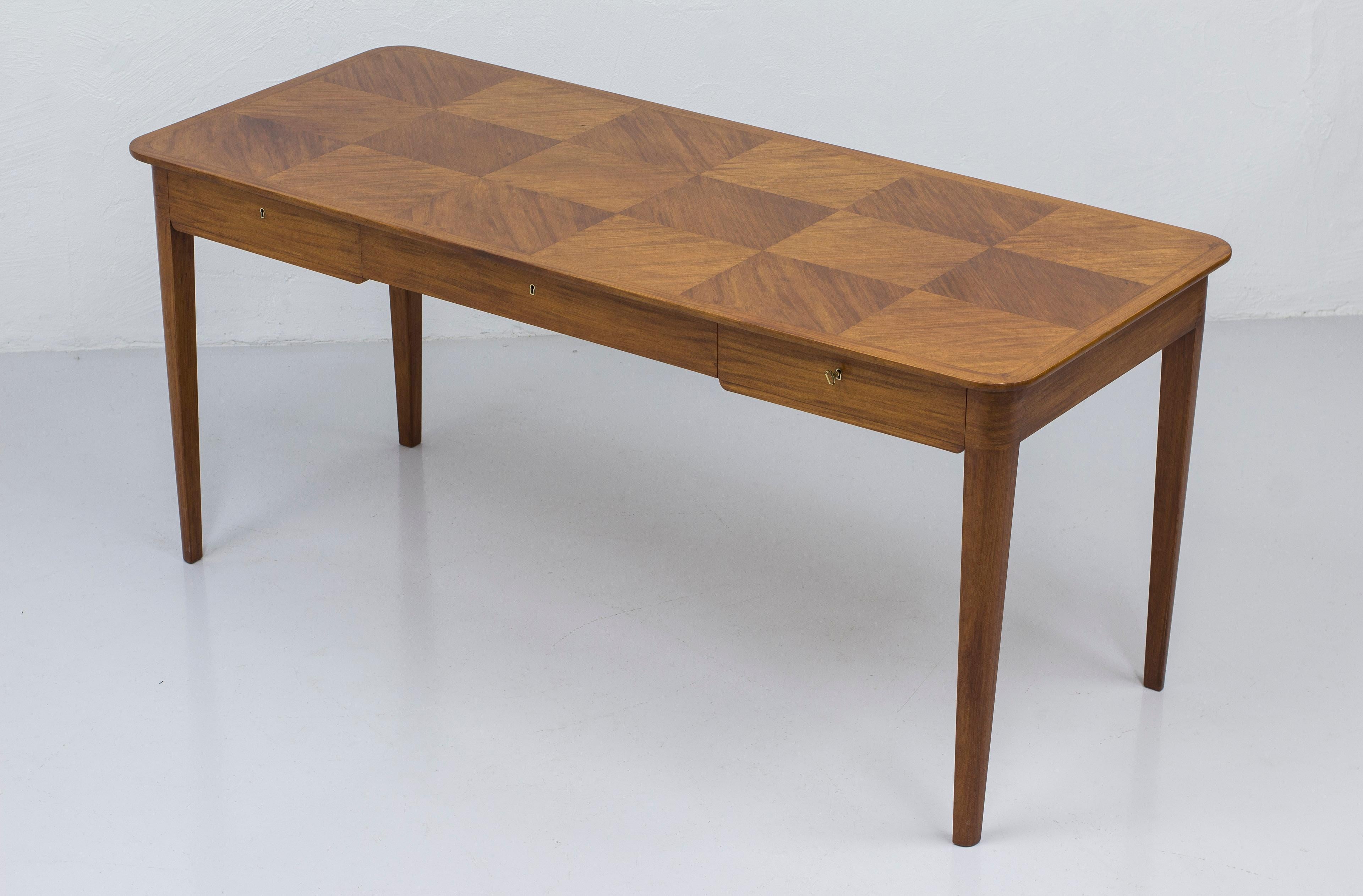 Swedish modern desk designed by interior architect Oscar Nilsson. Produced in Stockholm, Sweden by Cabinetmaker Allan Lindgren in 1938. Made from fruitwood with beautiful checker pattern on the table top. Beautifully crafted with solid wood on the