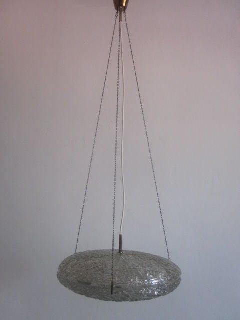 Elegante araña sueca de cristal soplado a mano de doble cara con una costura central abierta y revelada. Elementos luminosos encerrados en el centro. Suspendida de una pequeña cadena de eslabones. La altura mostrada es de 47