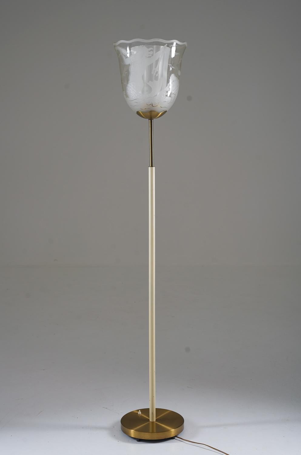 Ce majestueux lampadaire de Bo Notini pour Glössner, conçu et fabriqué dans les années 1940, est une véritable œuvre d'art. Cette lampe impressionnante comporte une source de lumière cachée par deux grands abat-jour en verre gravé, qui sont