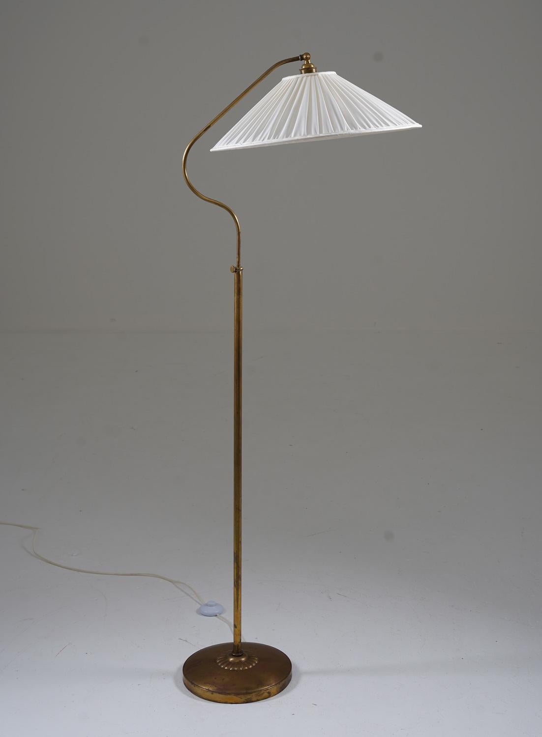 Schöne schwedische moderne Stehlampe, hergestellt in Schweden, 1940er Jahre. 
Die Leuchte besteht aus einem Sockel und einer Stange aus Messing, die einen schwenkbaren Arm tragen, der den Lampenschirm hält. 
Die Höhe ist zwischen 150-180cm