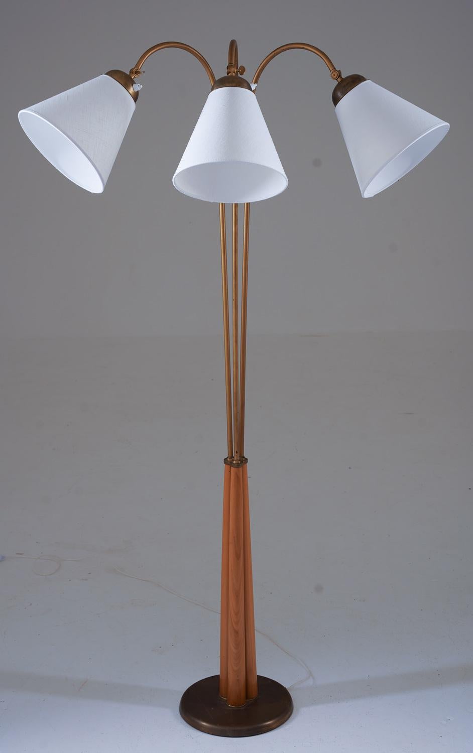 This is a lovely Swedish Modern floor lamp that was manufactured in Sweden during the 1940s. The lamp features three swivel arms, supported by wooden rods that are fixtures in the brass base.

Condition:
The lamp is in very good vintage condition,