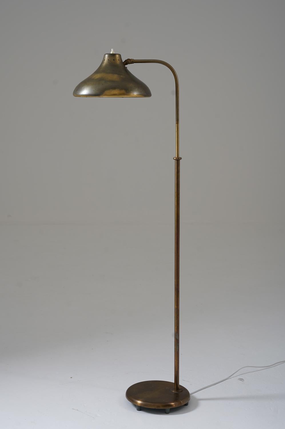 Rare Swedish Modern floor lamp model 5570 by Böhlmarks, Sweden, 1930s. 
This lamp is made of brass. The shade is fixtured on a swivel arm, which is adjustable in height (125-143cm, 49-56