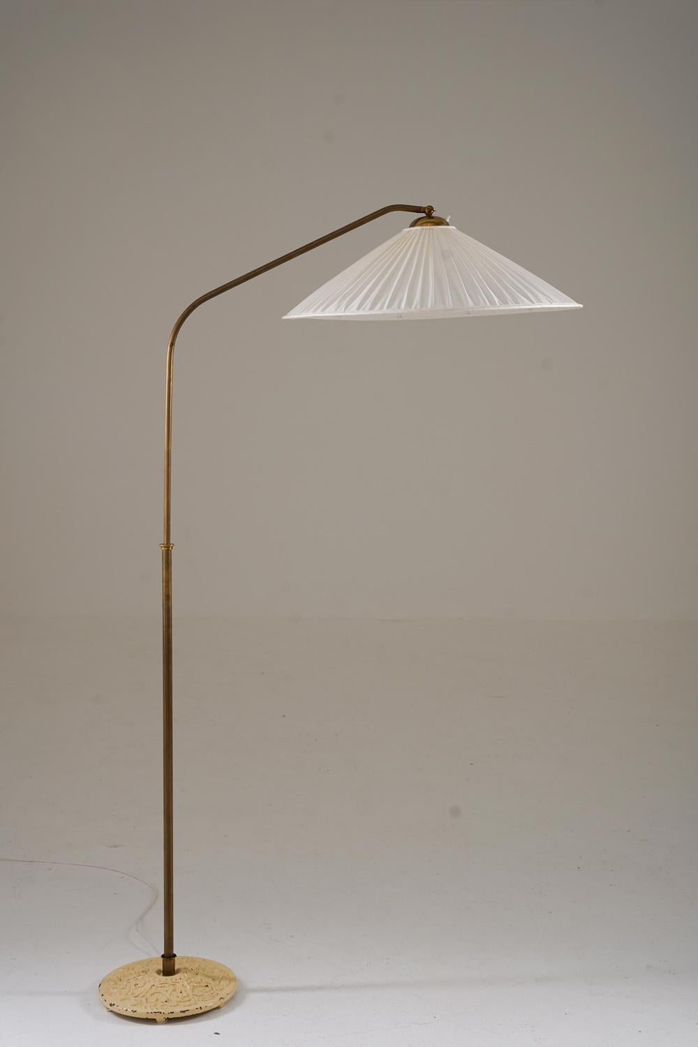 Il s'agit d'un joli lampadaire moderne suédois qui a été fabriqué en Suède dans les années 1940.
La lampe se compose d'une base en fer et d'une tige en laiton, qui soutient un bras pivotant qui porte l'abat-jour. Le bras pivotant est réglable en