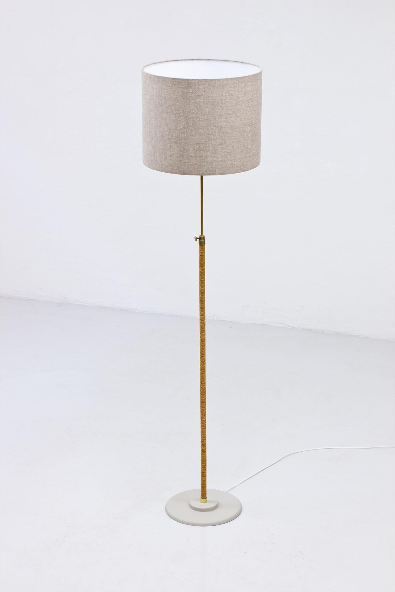 Scandinavian design floor lamp from an unknown maker. 
Most likely manufactured in Sweden during the 1940s. 
Polished brass, with lower section wrapped in rope stem. Lacquered metal base.
The stem is adjustable in the height. New wiring with