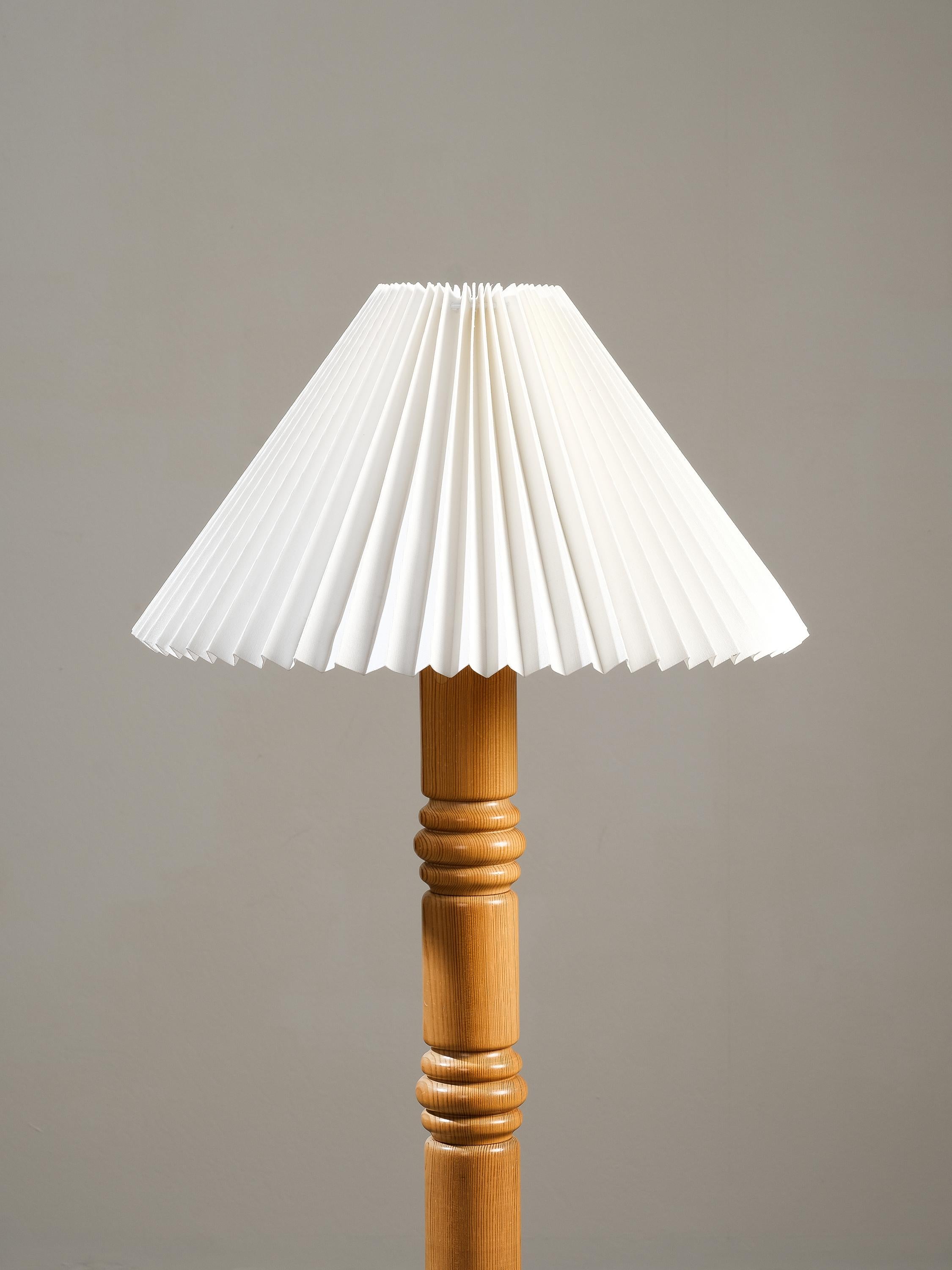 Esta llamativa lámpara de pie alta se fabricó en Suecia en la década de 1970.

El diseño moderno sueco se caracteriza por un tallo central de madera de pino maciza, con elementos tallados en forma de disco. La base circular también es de madera de