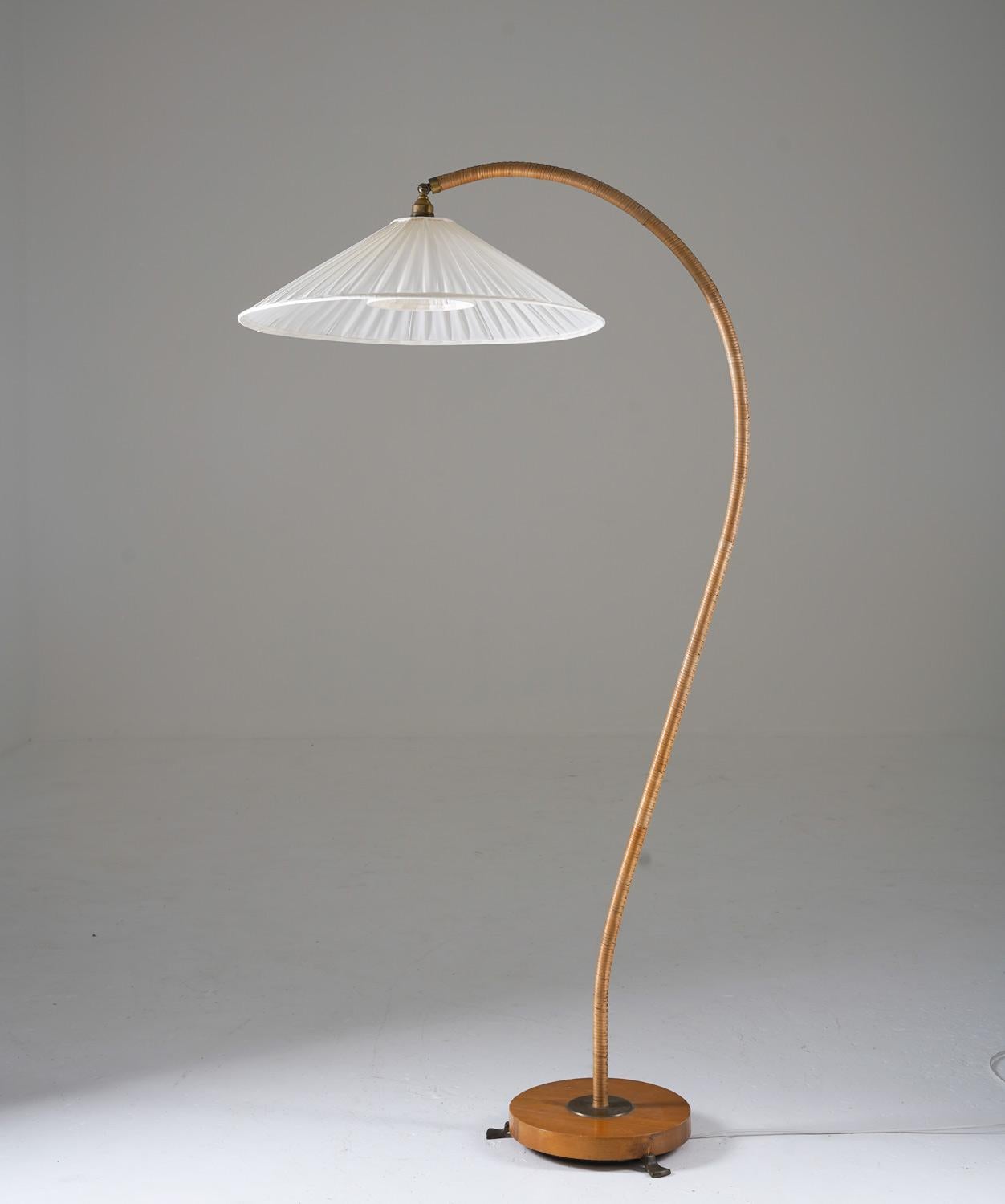 Majestic gooseneck floor lamp manufactured in Sweden, 1930s.
This floor lamp consists of a beautifully curved rod with rattan webbing. The rod is supported by a wooden base with brass details.

Condition: Very good condition, a few stains on the