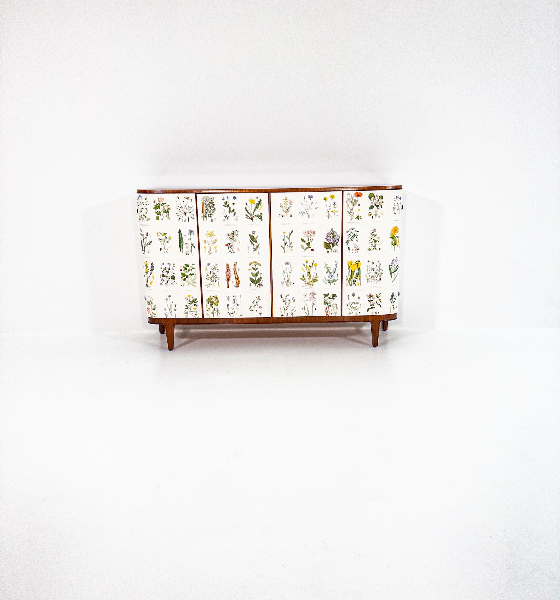 An exceptional Swedish Modern sideboard inspired by Josef Frank’s iconic floral cabinets.
This unique piece is upholstered with original botanical plates sourced from Nordens Flora, creating a poetic and museum-like visual expression. Every panel