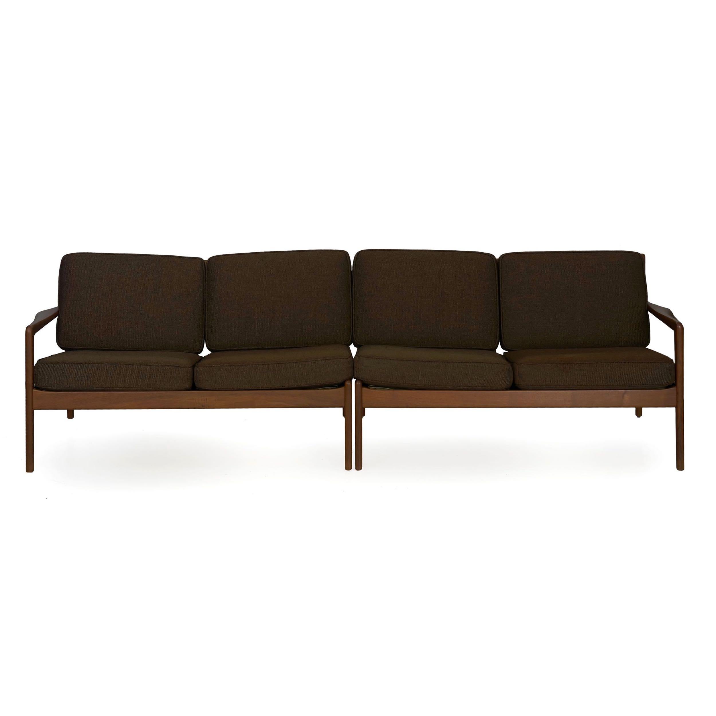 This pair of Mid-Century Modern sofas were designed by Folke Ohlsson for DUX in Sweden, an interesting design that allows them to operate either as a pair of loveseats, as a sectional with a table in the corner between them, or as a single long sofa