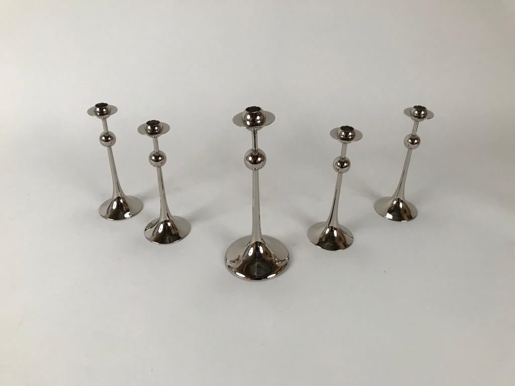 Set of five elegant Swedish modern saturnus silver plated candlesticks feature a sphere half way up the shaft and then a wonderful Saturn shaped bobeche at the top. Designed by Kjell Engman for Gense of Sweden in 1979. This group is in near mint