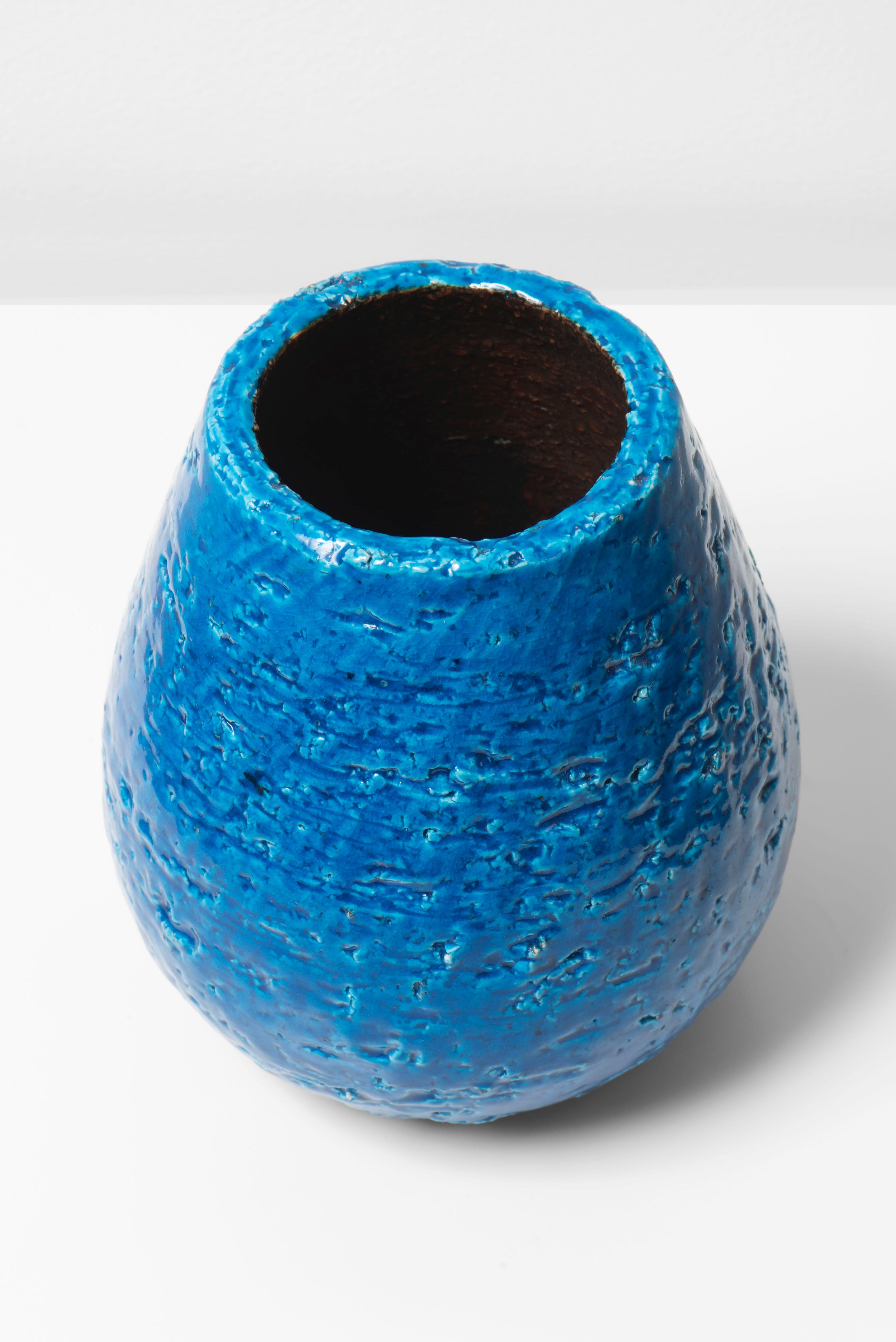 Creation by Gunnar Nylund (1914–1997) during his tenure as artistic director of Rörstrand from 1932 through the 1950s. The vase has a glossy white glaze over a rough rustic body creating a smooth touch but a brutal look to the piece. The Chamotte