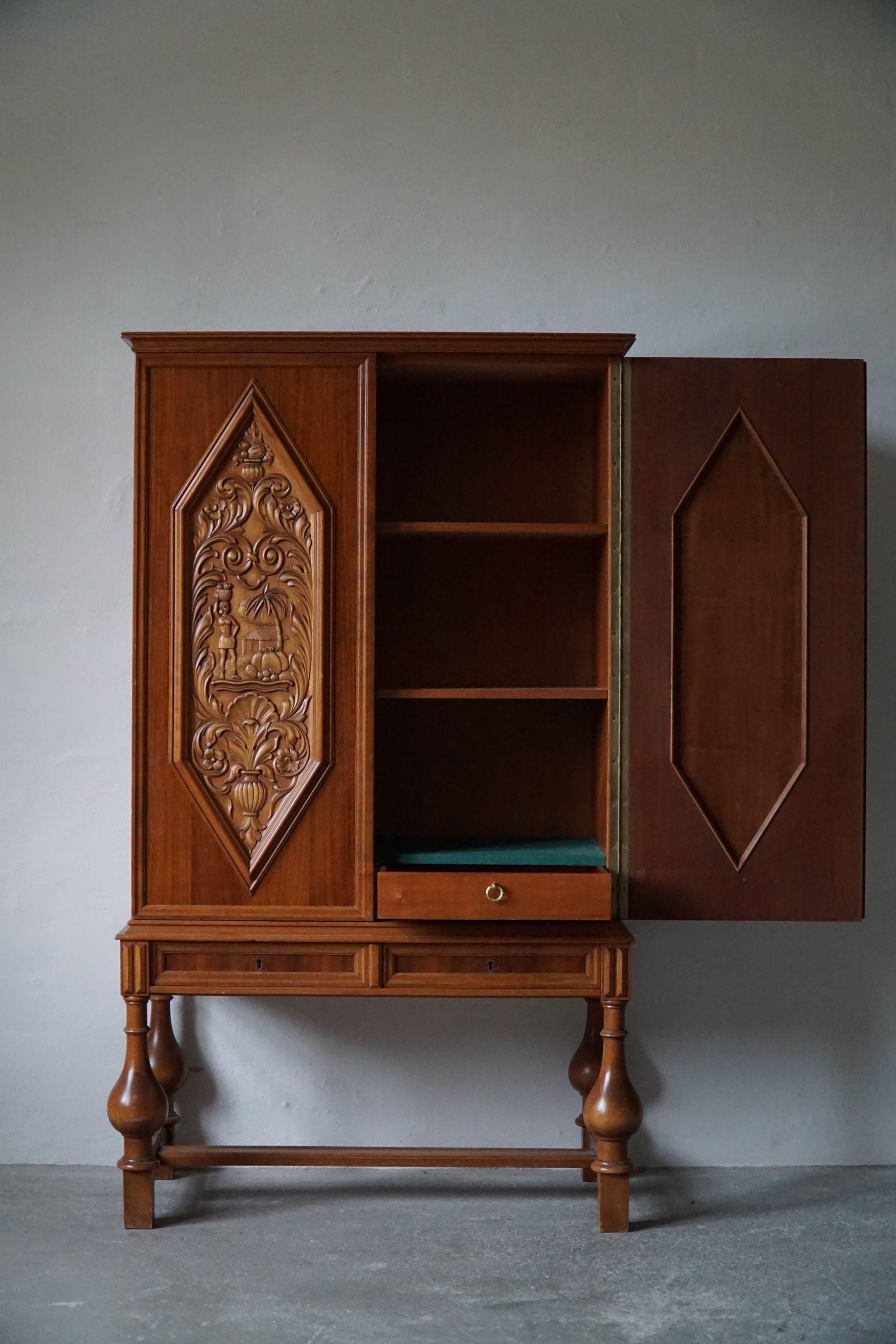 Sculptural cabinet in walnut and beech. Made by Swedish designer Eugen Höglund for Vetlanda in 1940s. 

Hand carved panels with a figurative landscape. Inside adjustable shelves and drawers.

This fine object will match many kinds of interior