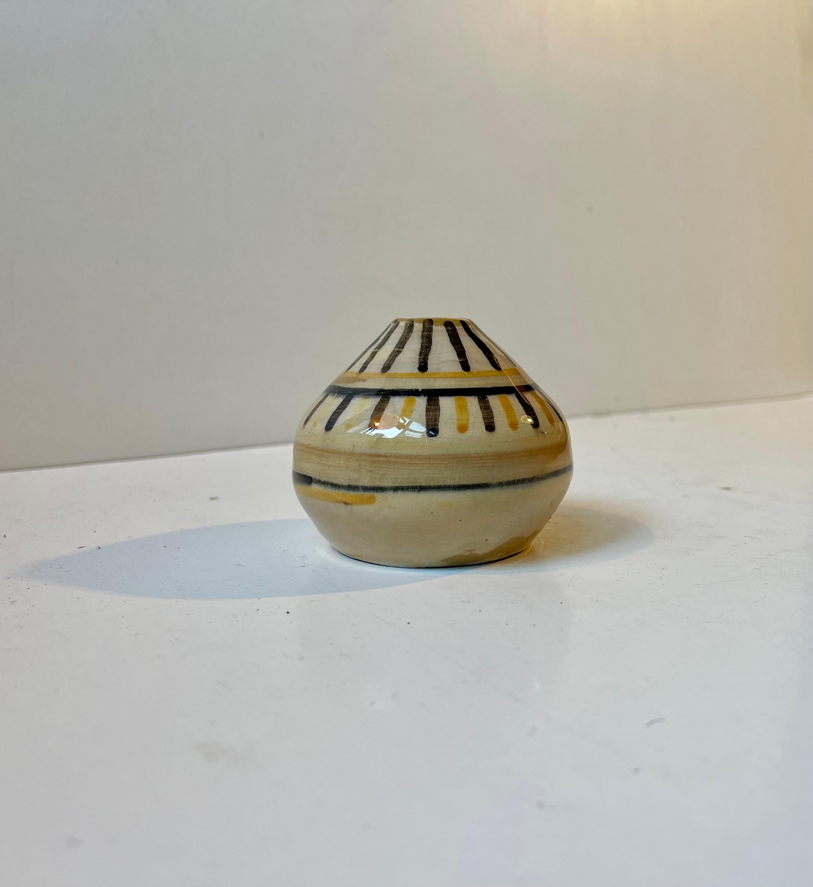 Piccolo vaso di ceramica funzionalista firmato BO - 44. Forse un pezzo da studio di Bo Fajans in Svezia. Grano pastello decorato a mano con strisce gialle e nere.
Misure: H: 6,5 cm, P: 7,5 cm.