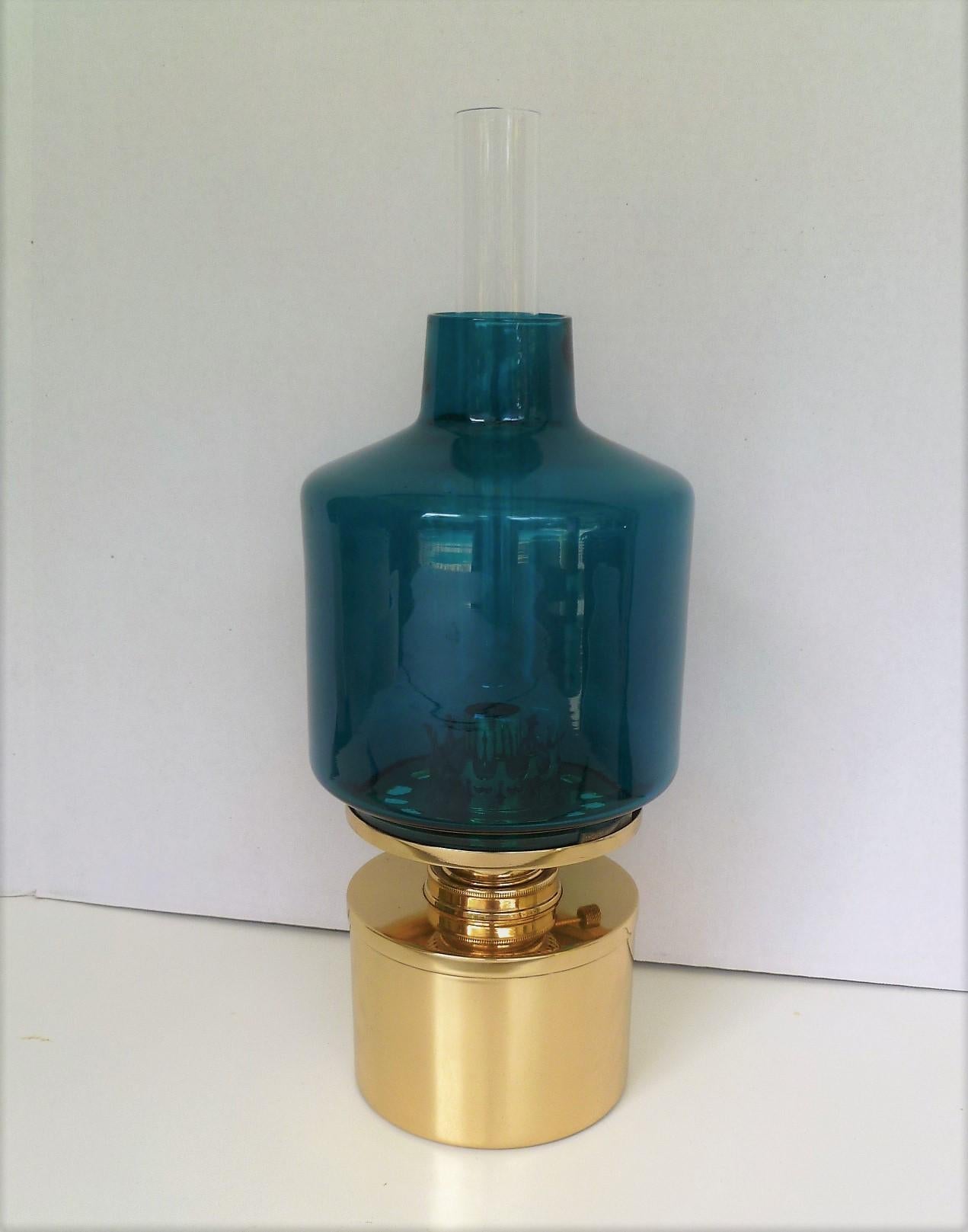 Kerosene oil lamp designed by Hans-Agne Jakobsson for AB Markaryd in the 1960s. This is the large L-47 model with the brilliant blue outer shade and clear inner chimney. The brass has been professionally polished. The lamp does not come with a wick;