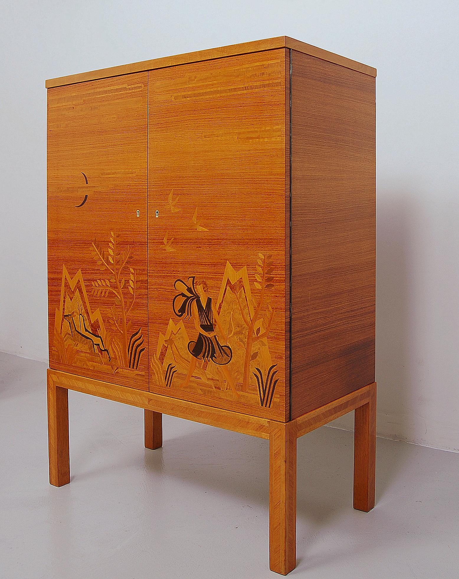 Elegant dry bar cabinet with beautiful intarsia veneer showing Diana, the goddess of the hunt, moon, wild animals and fertility. Produced by Reiners Möbelfabrik in Mjölby. Marked in back with manufacturing date, 27 July 1939. Very good condition.