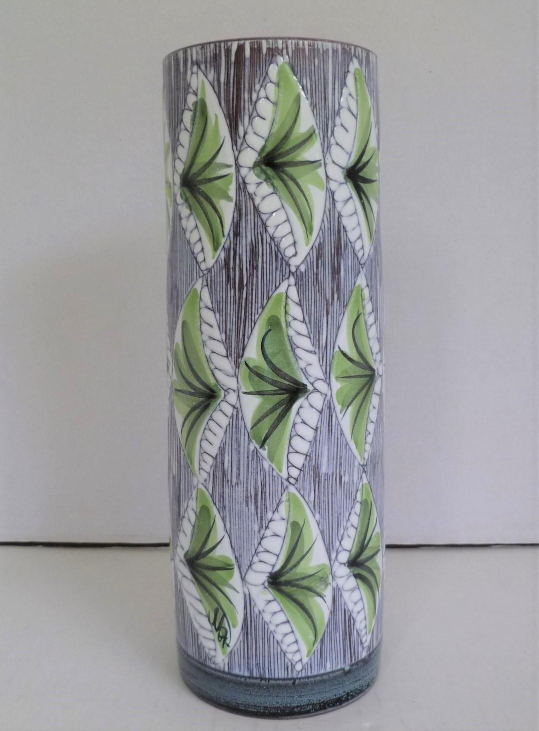 Lovely 1960s cylindrical Swedish modern ceramic vase from the Laholm pottery with hand painted plants/leaves in lime green on a sgrafitto design over the white underglaze. The carved pattern creates the soft textured feel of the vase while the