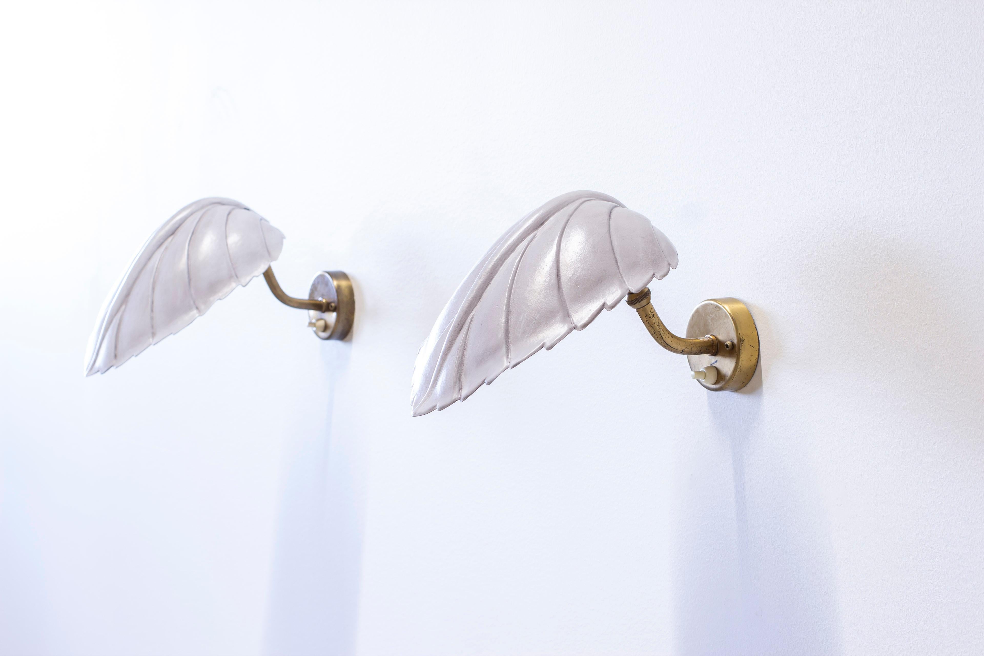 Pareja de lámparas de pared diseñadas por Hans Bergström. Producido en Suecia por Ateljé Lyktan durante la década de 1940. De latón y pantallas de cobre lacado en gris. Interruptores de las lámparas en buen estado de funcionamiento. Muy buen estado