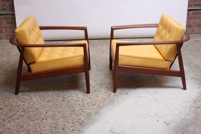 Folke Ohlsson for Dux of Sweden sculptural staved-teak lounge chairs (Model 72-C) featuring a rounded / slatted back and loose cushions. Frames have been refinished and strapping is new. Newly upholstered in canary yellow leather with tufted and