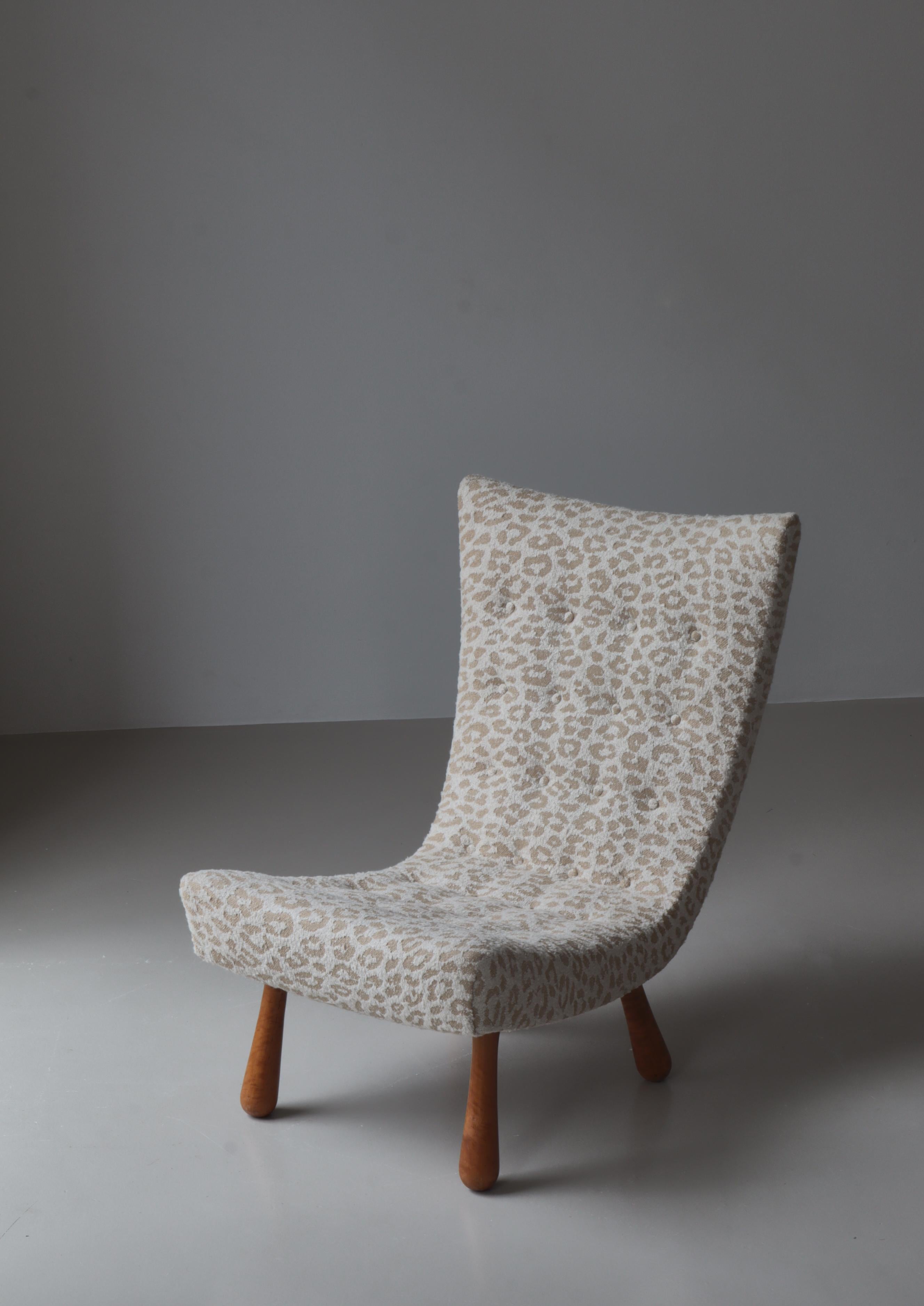 Wonderful lounge chair made in Sweden in the 1940s. The curves are similar to that of the contemporary clam chair. The legs are made from solid turned birchwood and the frame has been reupholstered and hand sewn in sand coloured 