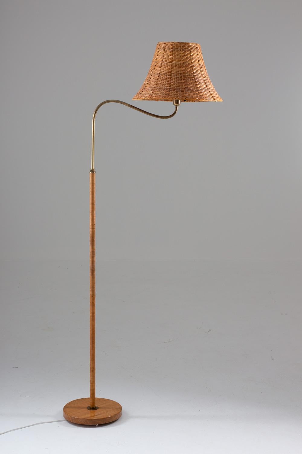Rare floor lamp manufactured in Sweden, 1940s.
Very elegant lamp of beautiful design. The pole is entwined in rattan, with details in brass, such as the screw that makes it possible to adjust the height of the lamp. The swivel arm makes it perfect