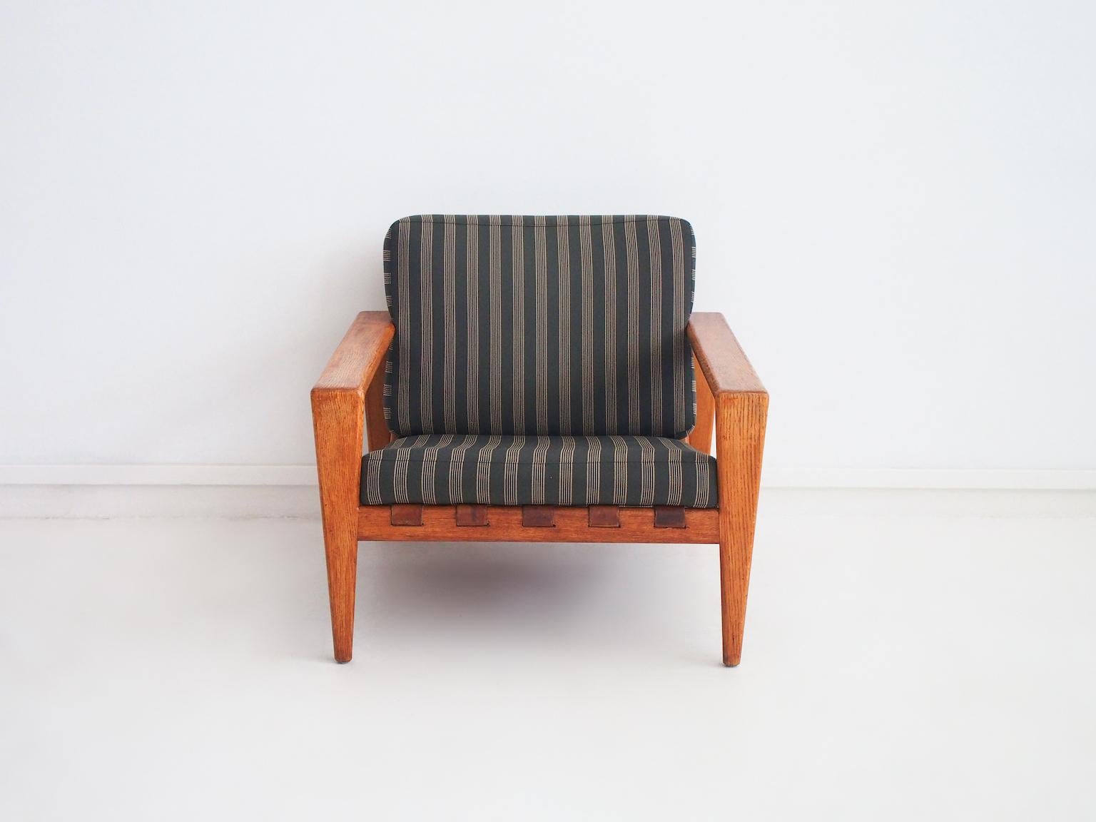 Sillón, modelo Bodö, diseñado en 1957 por Svante Skogh. Fabricado por AB Hjertquist & Co en Nässjö, Suecia. Estructura de roble, asiento de cuero, cojines tapizados en tela de rayas. Este sillón de líneas limpias es un buen ejemplo de estilo moderno