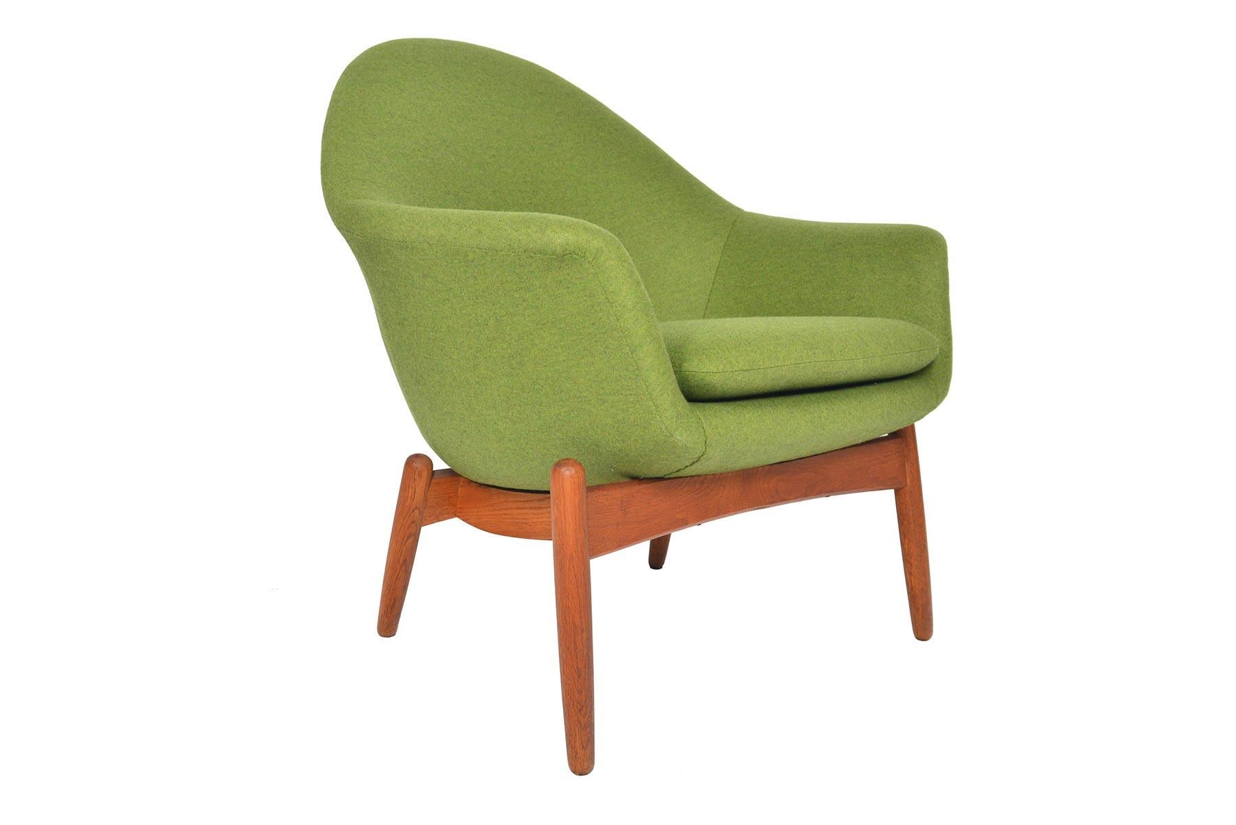 This beautiful Swedish Mid-Century Modern oak lounge chair was designed and produced in the 1960s by Scapa. This lovely curvaceous design offers a striking organic silhouette from every angle. Newly upholstered in felted green wool by Kravet. The
