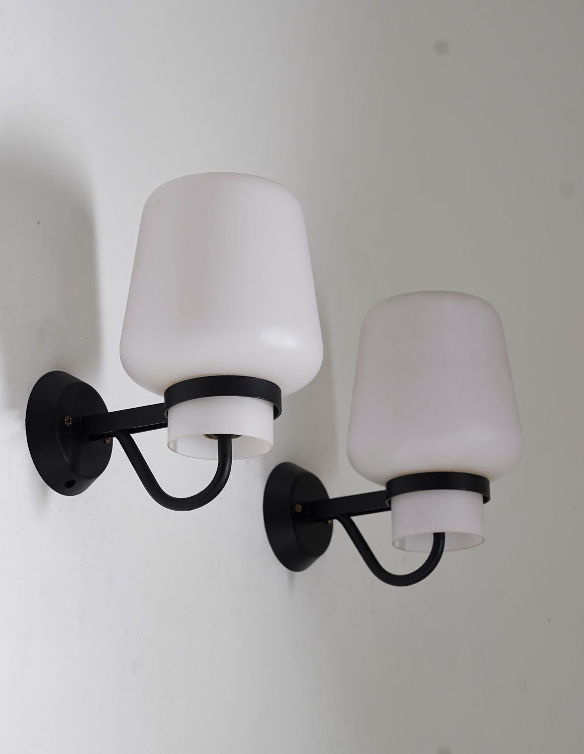 Large wall lamps by ASEA, 1960s.
These lamps feature a large frosted opaline glass shade, resting on a frame of iron.

Condition: Good condition, the frames have been re-laquered at some point