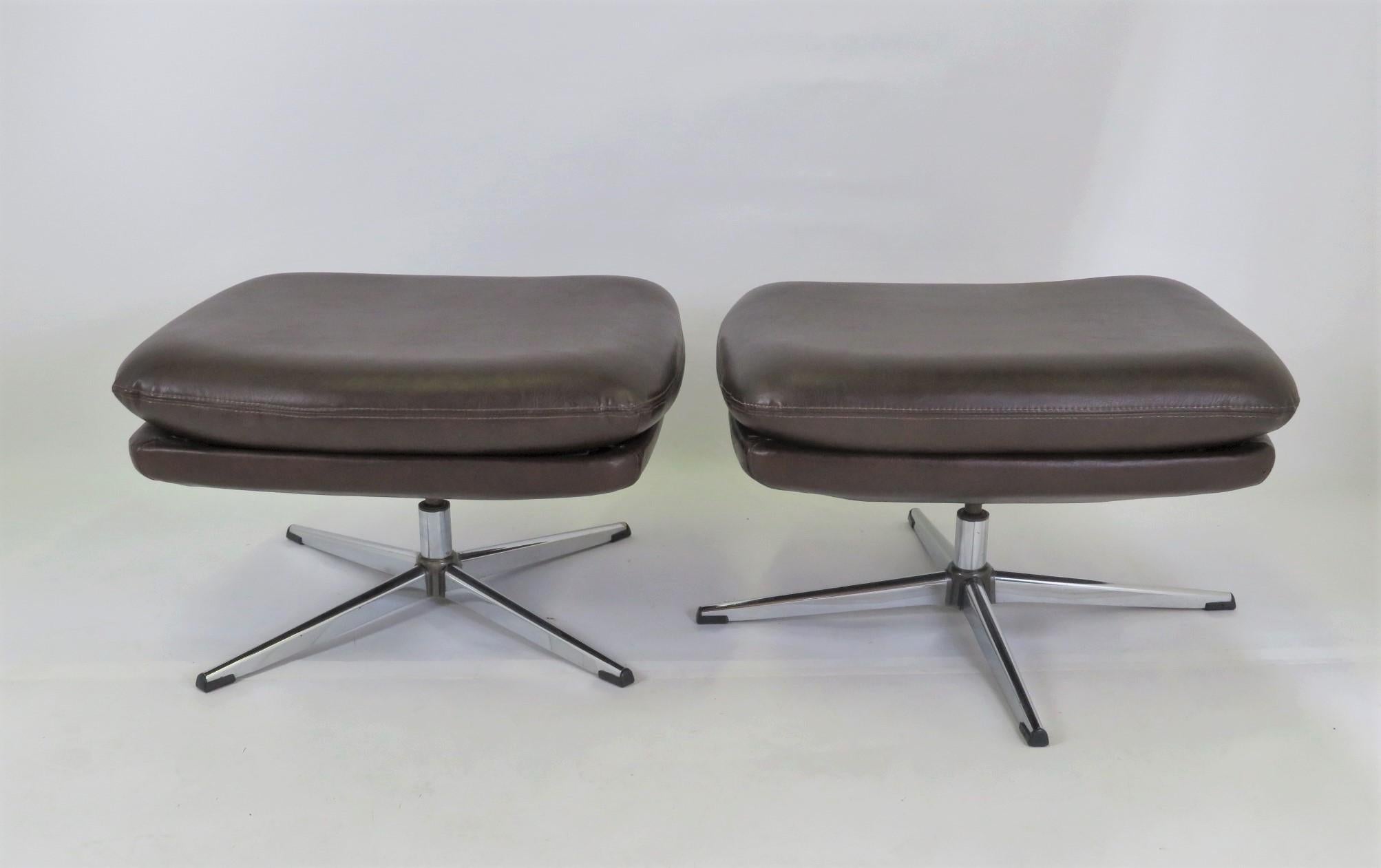 Great pair of Overman footstools benches in brown leatherette and chrome feet. These were manufactured in the 70s in Tennessee by Overman USA. They have four point star bases and swivel. Feet have their original glides. In very good