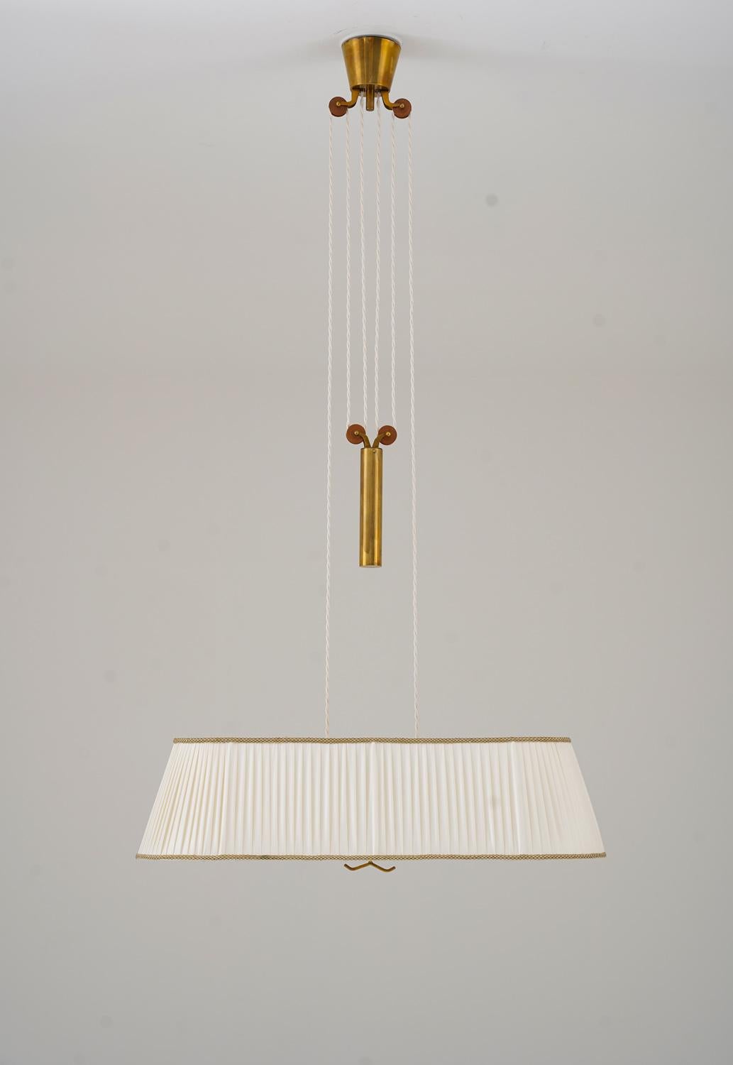 Rare pendant model 11827 by Harald Notini for Böhlmarks, Sweden
This elegant pendant consists of a brass canopy and counter weight, that allows you to adjust the lamp to the height you prefer. The four light sources are hidden by a large pleated