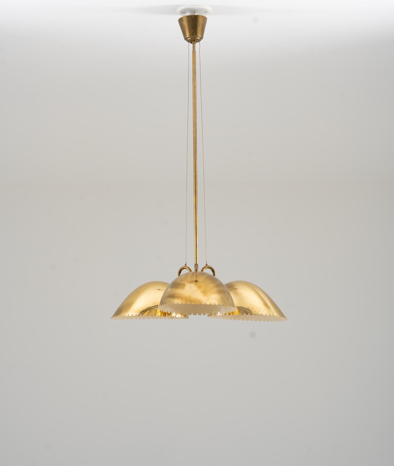 Swedish Modern pendant in brass, designed by Harald Notini and manufactured by Böhlmarks, Sweden, 1940s.
This impressive pendant is made with high quality and great details. It features three light sources, hidden by large perforated brass