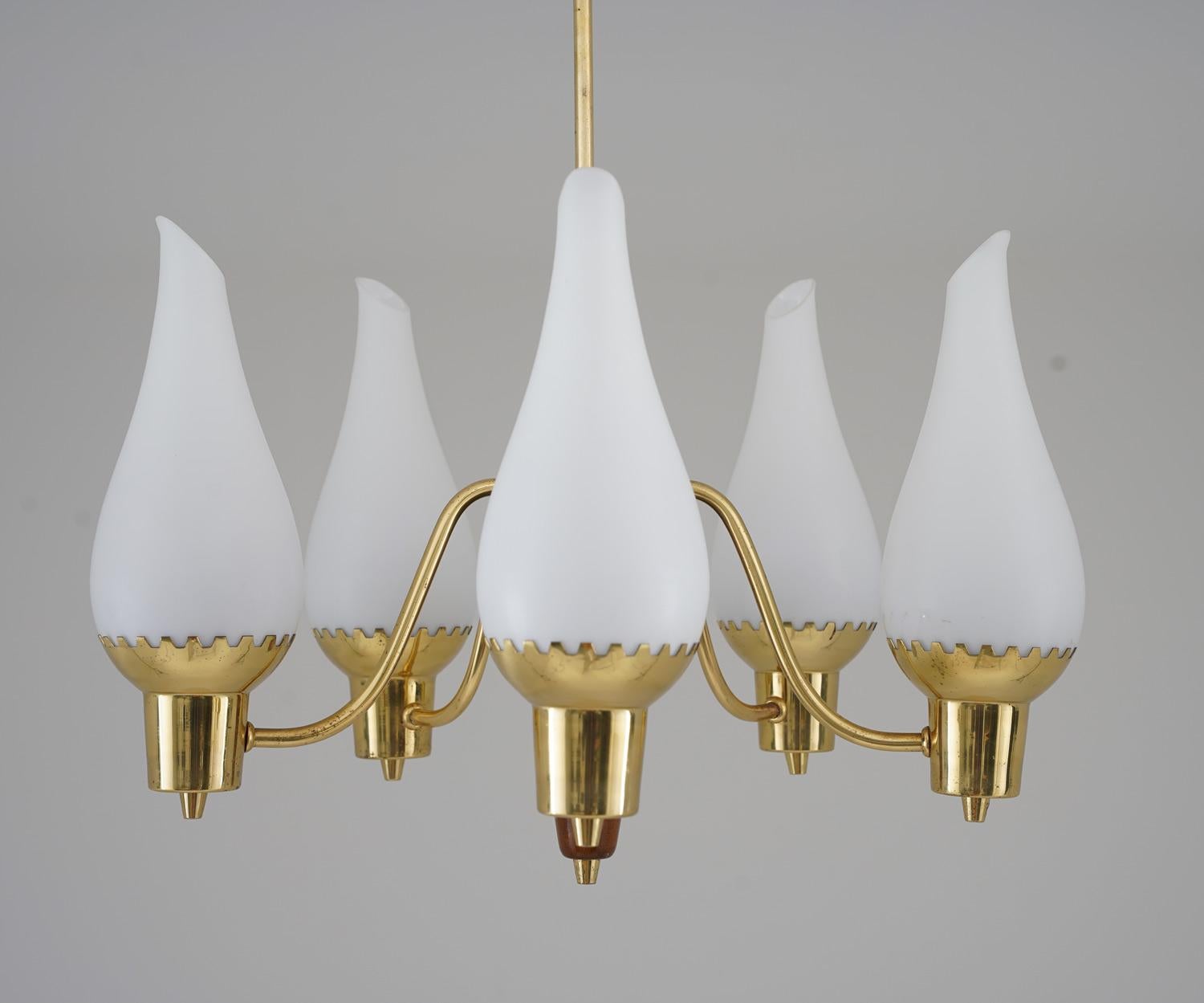 Rare midcentury pendant in brass, wood and frosted opaline glass, manufactured in Sweden, 1940s.
This pendant is made with a high sense of quality and has great details. It features five light sources, hidden by frosted opaline glass shades. The