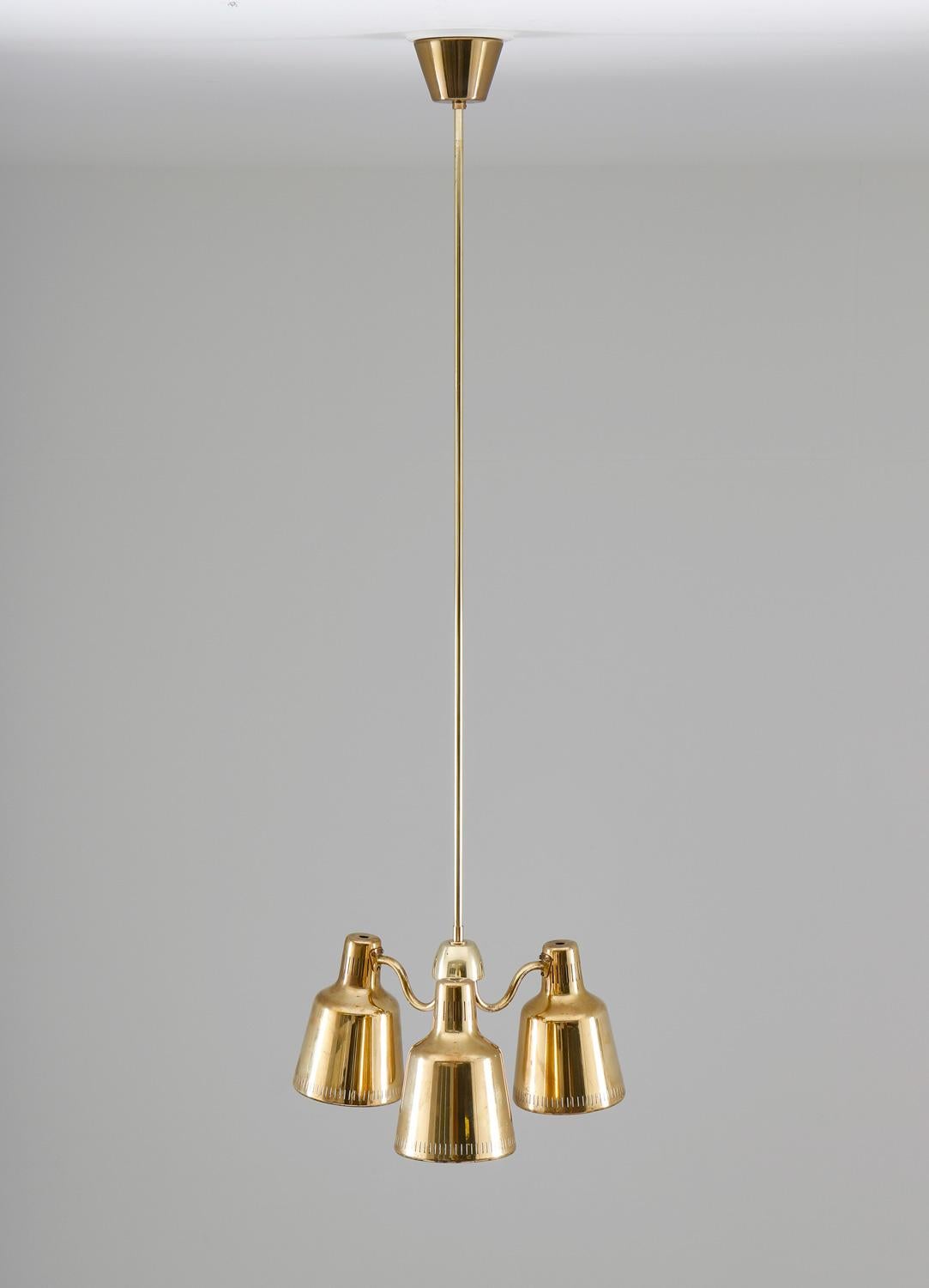 Rare Swedish modern pendant, possibly designed by Hans Bergström.
This pendand features three light sources, hidden by beautiful perforated brass shades. The shades are connected to a center piece, where the brass rod, holding the lamp, is