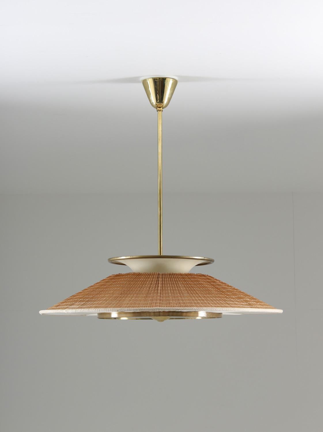 Rare Swedish pendant, possibly manufactured by Böhlmarks, circa 1940.
This large pendant features six light sources; two uplights and four downlights. The bulbs are hidden by a frosted glass diffuser surrounded by white fabric. The hood is made of