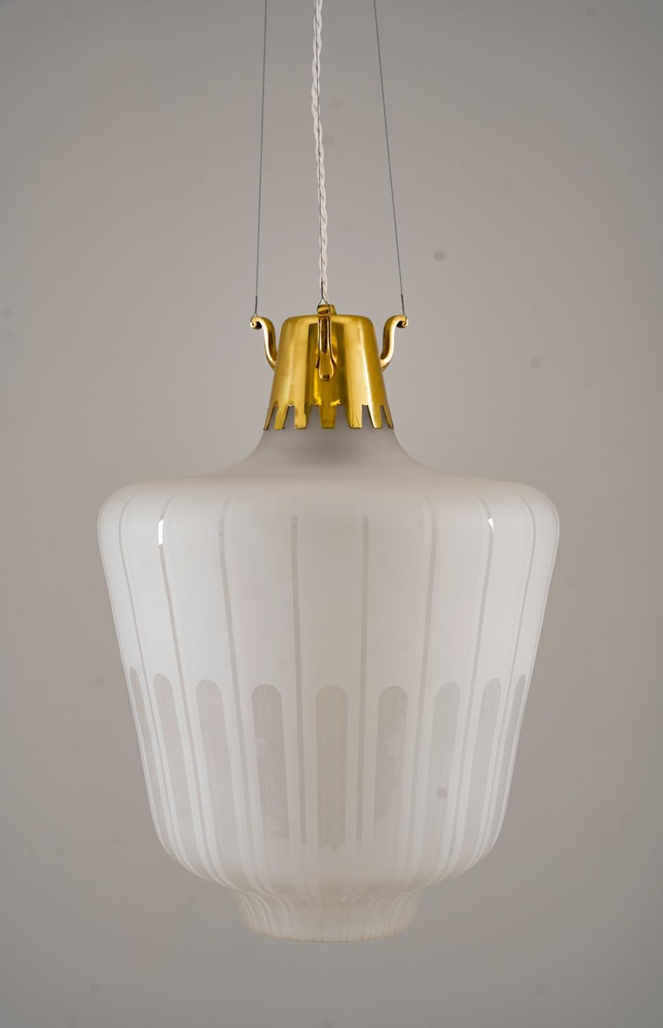 Large set of model 1588 by Bröderna Malmströms, Sweden. 
This model features a large blasted glass shade with blank patterns. The shade is attached to a brass top with three wires, holding the fixture.
The length of the wires and brass rod can be