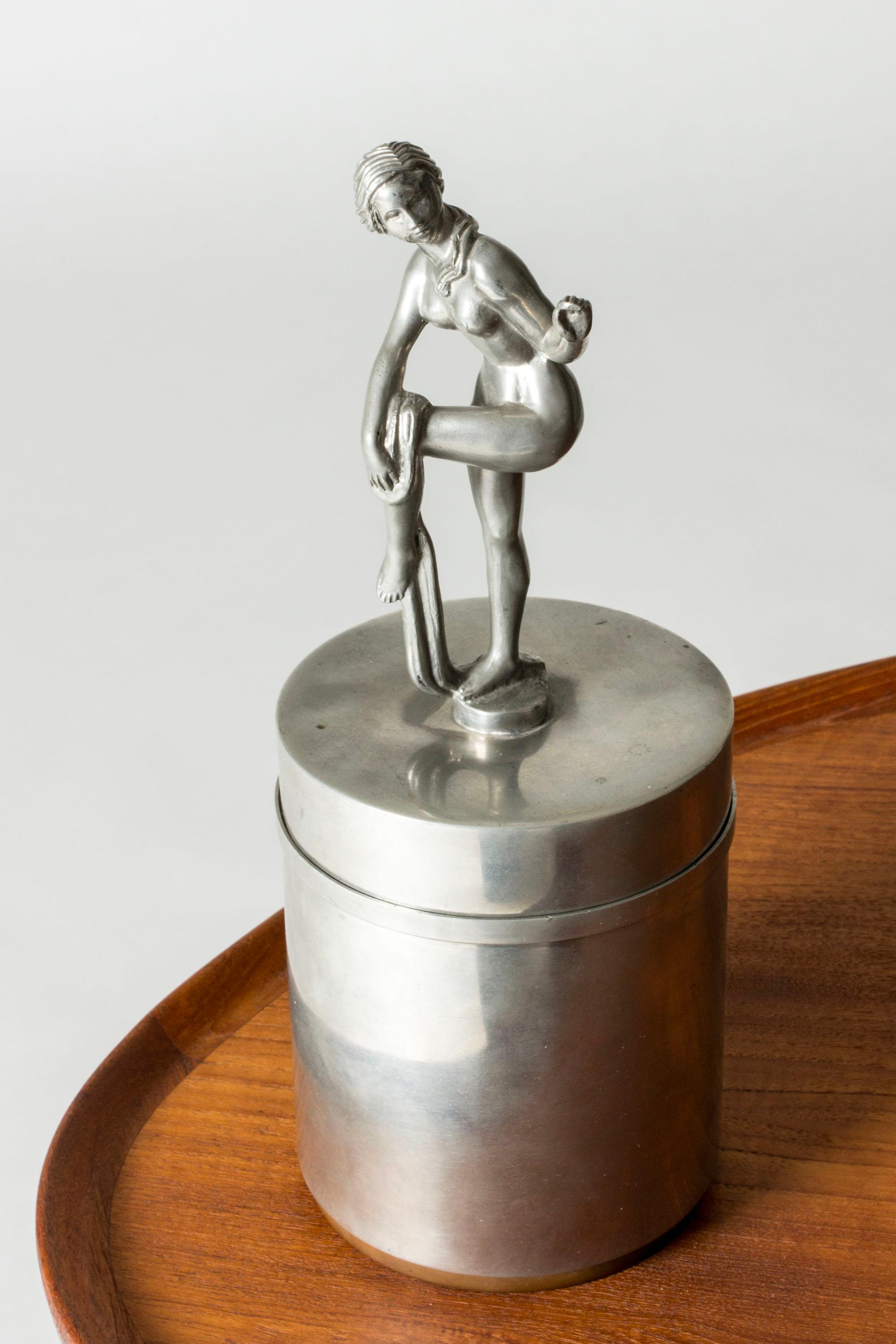 Splendido vaso in peltro di Athena Ystad, con un coperchio dal design elaborato. Decorata con una statuetta femminile che si asciuga dopo un bagno. Un'ottima attenzione ai dettagli.