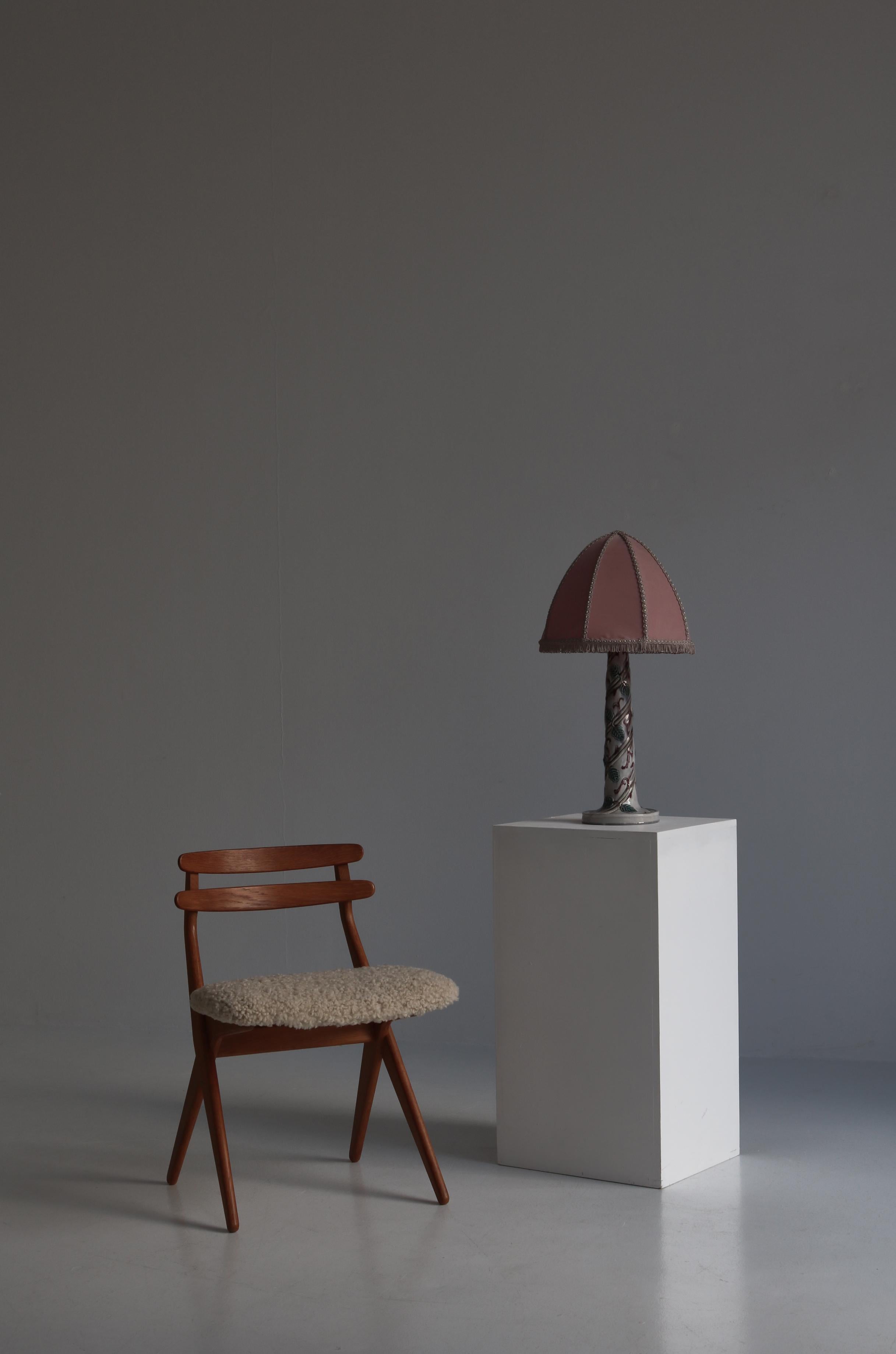 Wunderschöne und einzigartige Tischlampe der schwedischen Künstlerin Louise Adelborg aus den 1920er Jahren. Der Lampenfuß ist aus glasiertem Porzellan mit handgefertigtem Laubdekor. Die Lampe ist mit dem originalen handgefertigten rosa Schirm