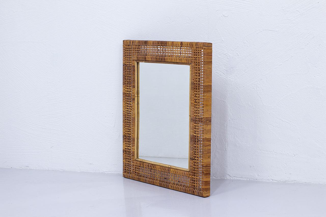 Swedish modern mirror manufactured in Sweden during the 1950s.  
Solid teak frame with hand woven rattan. 
Beautifully aged color on the cane. 
Good vintage condition with light wear and patina.