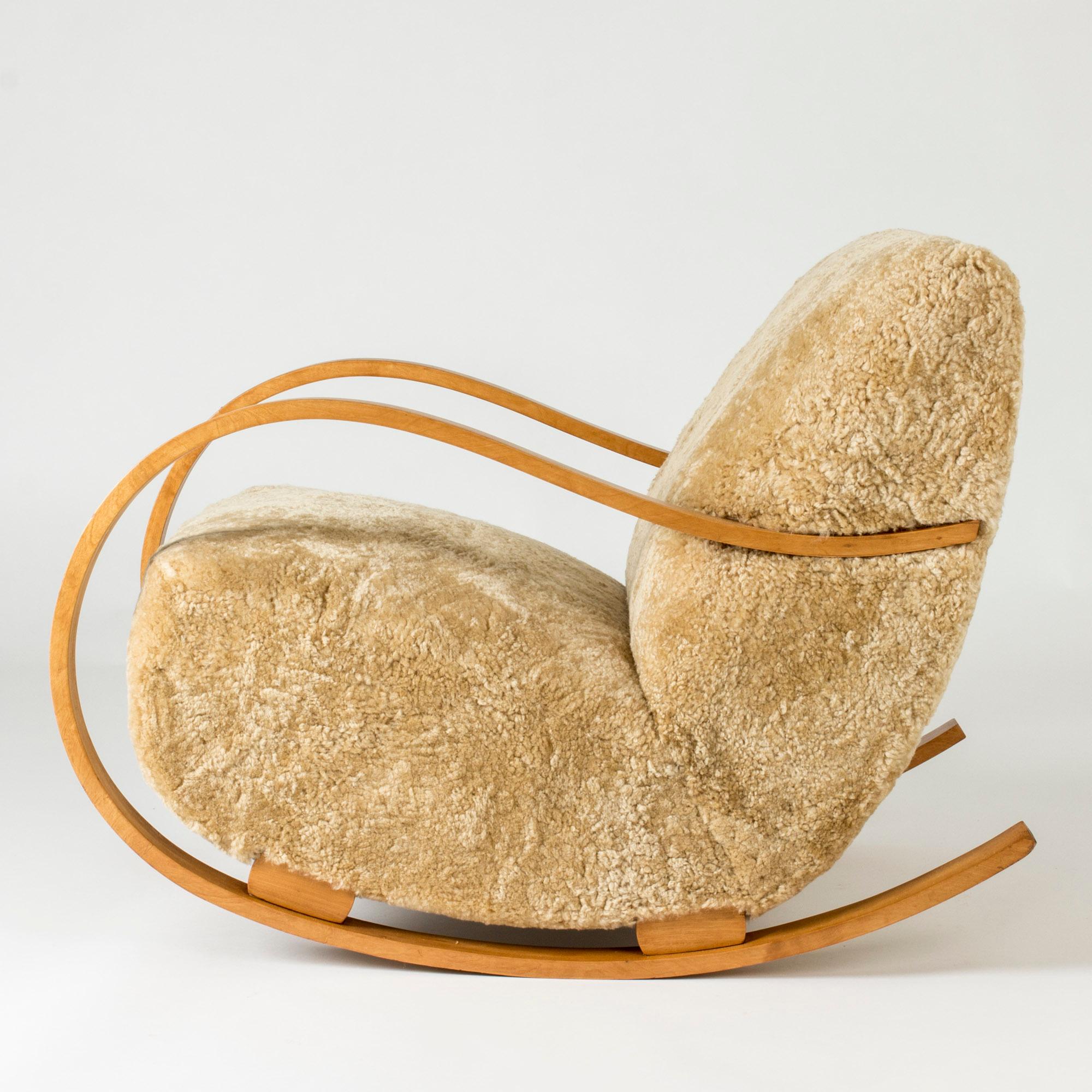 Cool Swedish Modern rocking chair with generous, curved lines. Made from bentwood with chunky details, upholstered with sheepskin. Very comfy.