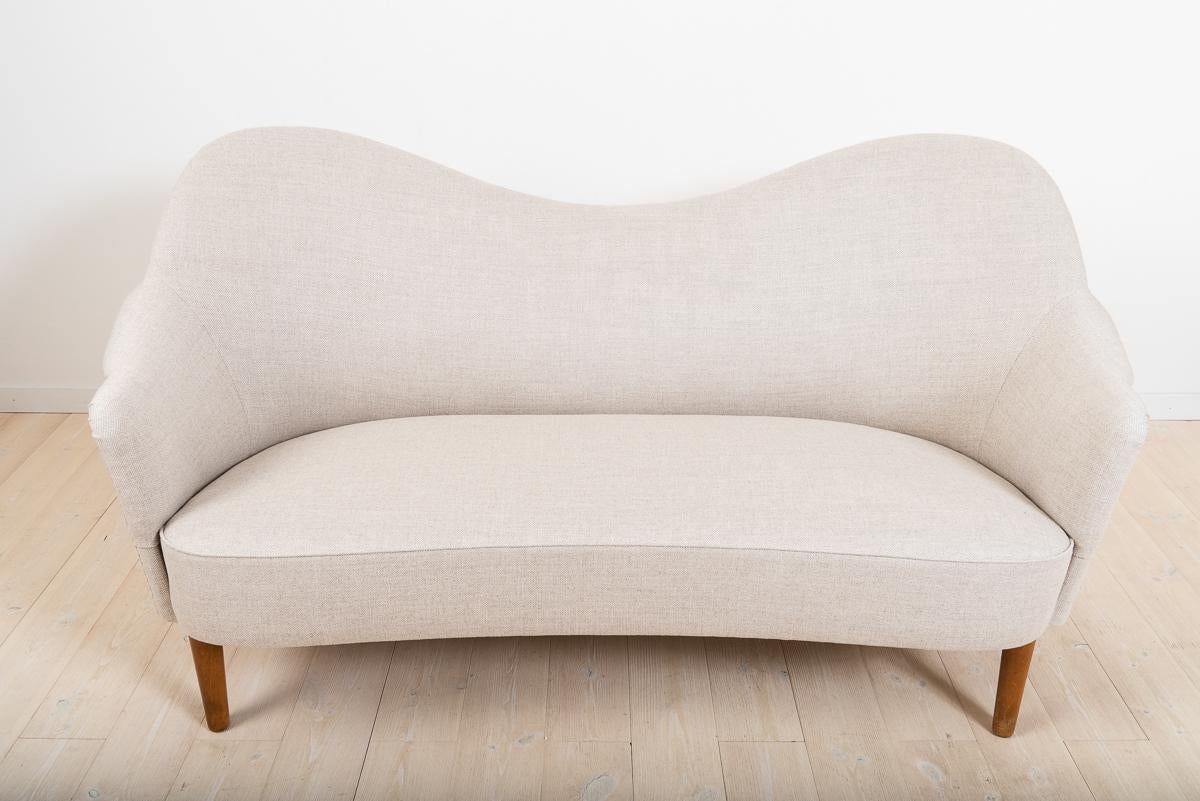 This Samspel 2 seaters sofa has been reupholstered. It was created by Carl Malmsten, one of Sweden's best known furniture designers. Born in Stockholm in 1888 and dead in 1972, the artist spent his life creating practical furniture inspired by