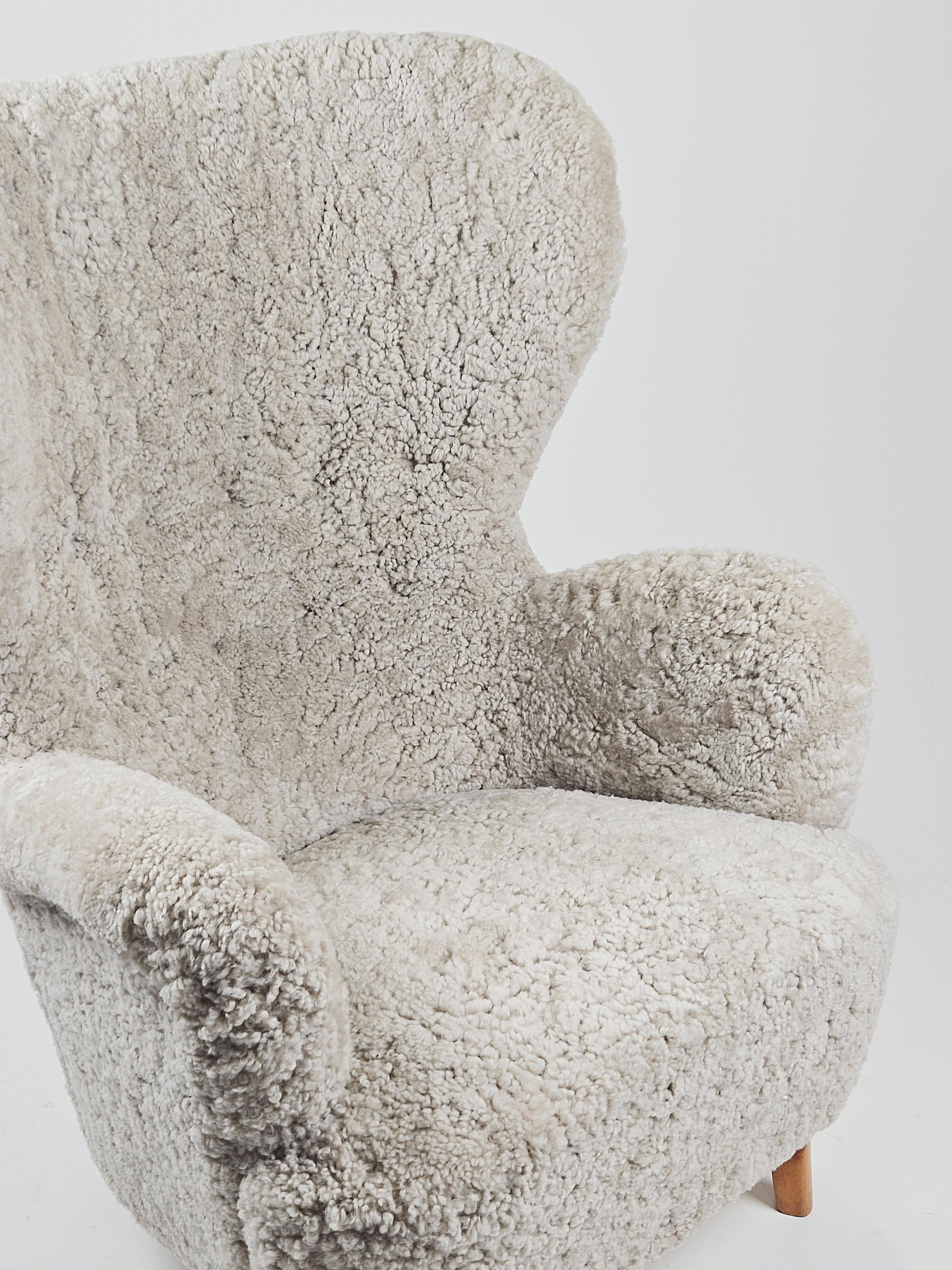 Eleganter und luxuriöser Sessel im Stil von Otto Schulz aus der Mitte des 20. Jahrhunderts. 

Gepolstert mit hochwertigem Schafsfell und passenden Wollknöpfen an der Rückenlehne. 