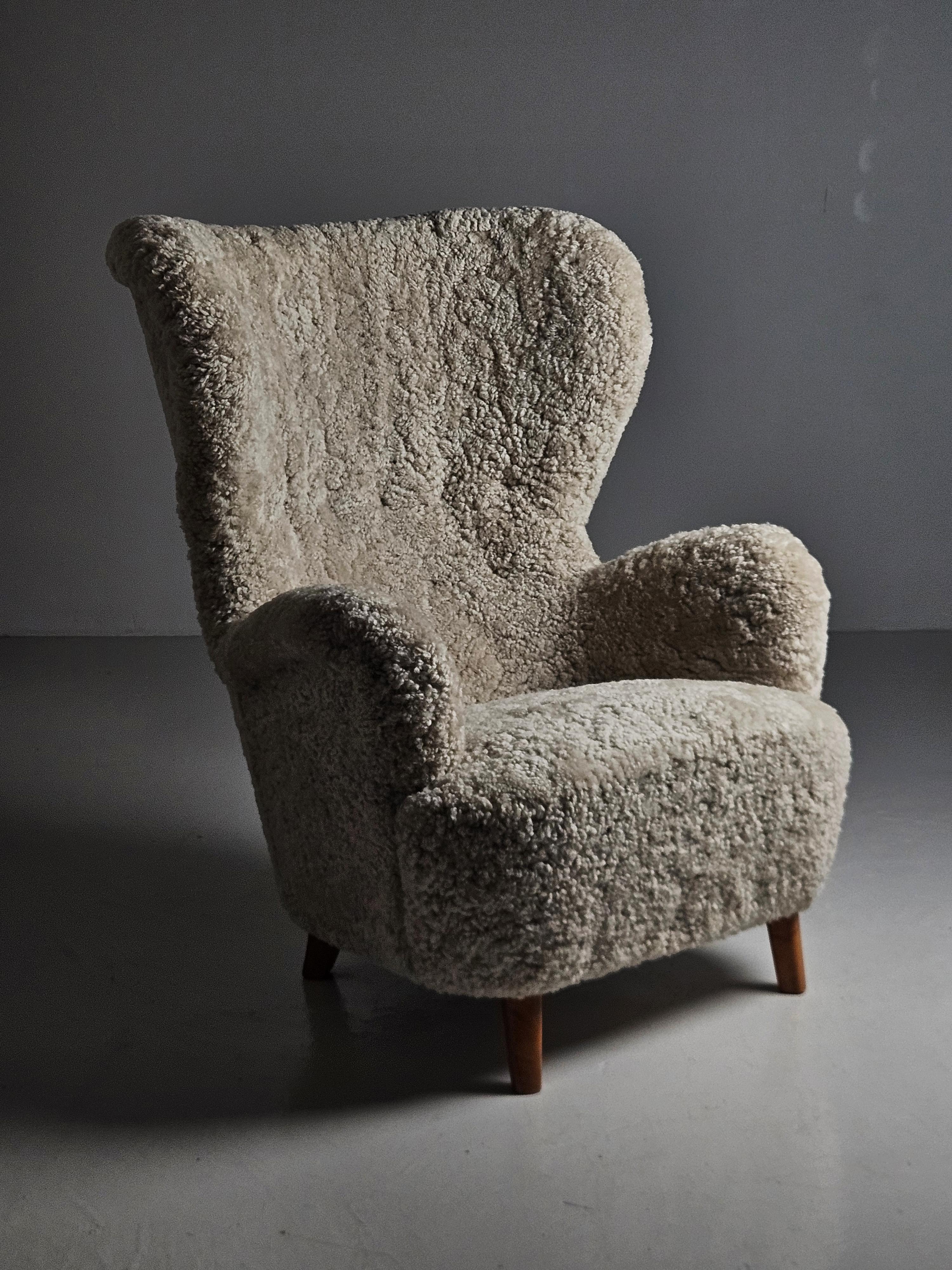 Elegant and luxurious lounge chair in the style of Otto Schulz from the middle of the 20th century. 

Upholstered in high quality sheepskin with matching wool buttons on backrest. 