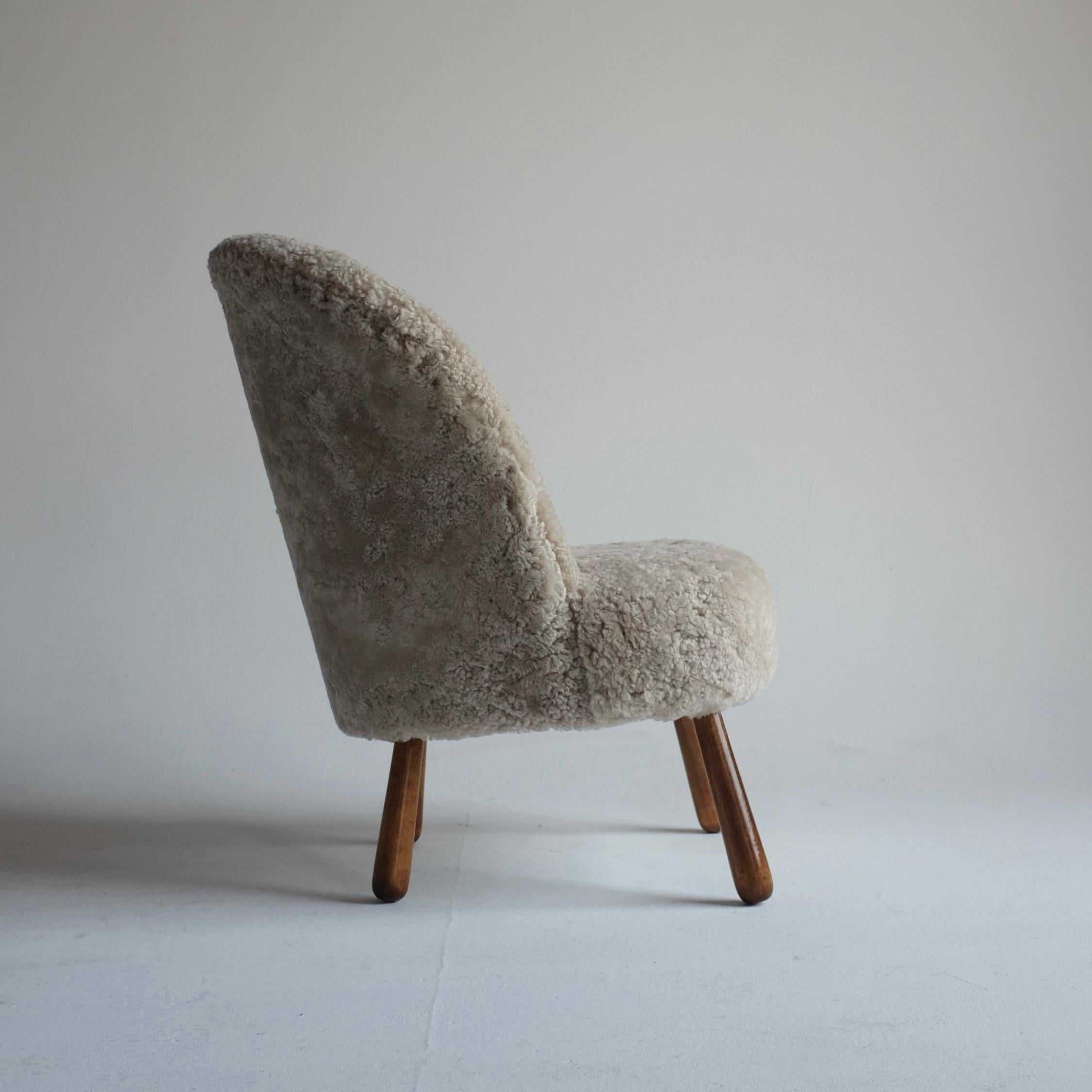 Chaise d'appoint suédoise moderne, nouvellement recouverte de peau de mouton de haute qualité par Scandilock. Cette chaise date probablement des années 1940 et a été réalisée par un designer inconnu. Elle est dans le style de la célèbre chaise Clam