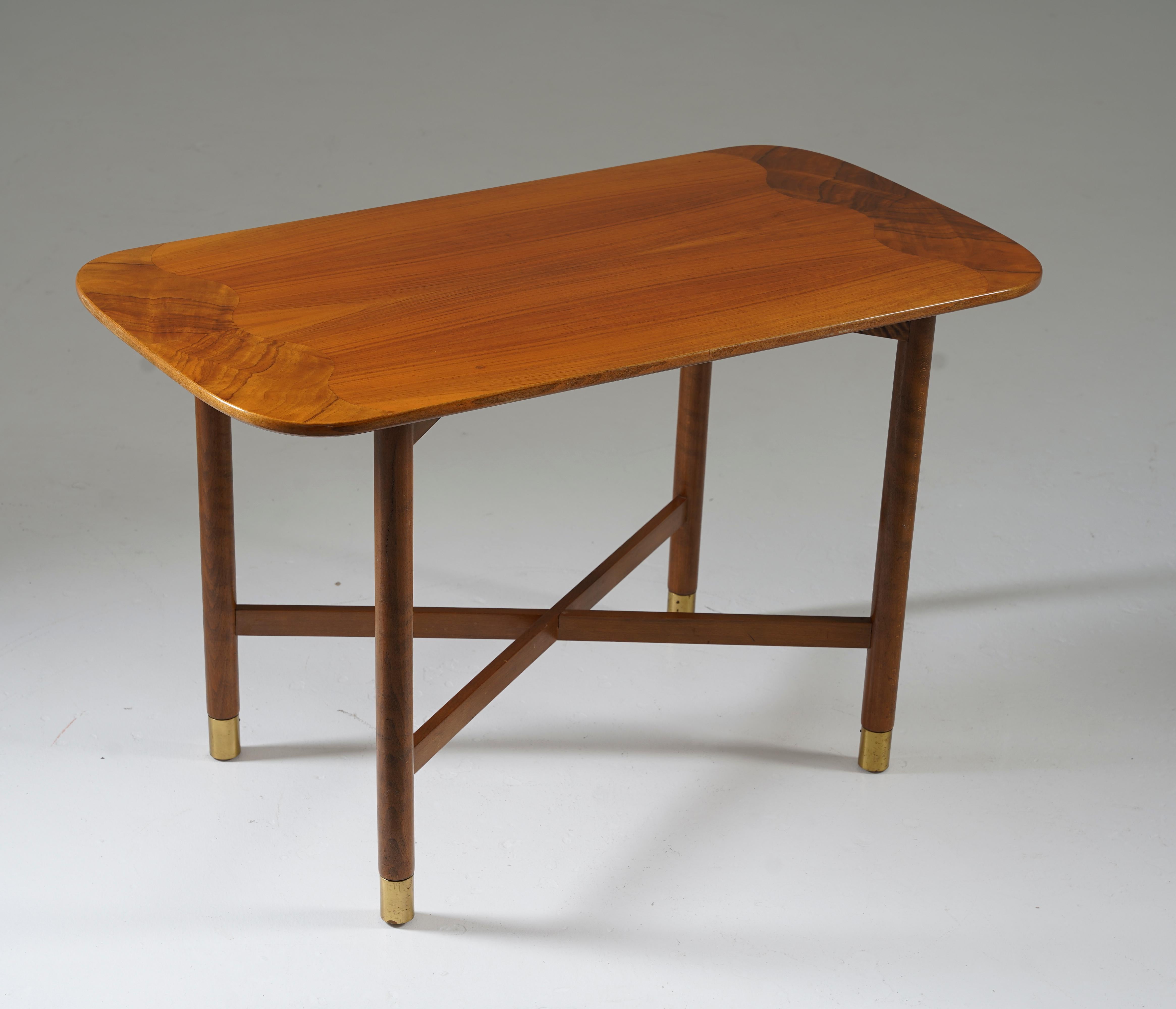 Swedish modern side table or coffee table, 1940s. 
This table offers a very clean design and superb craftsmanship, significant for the era. The wave-shaped inlays and brass details add elegance to the minimalistic design. 

Condition: Very good