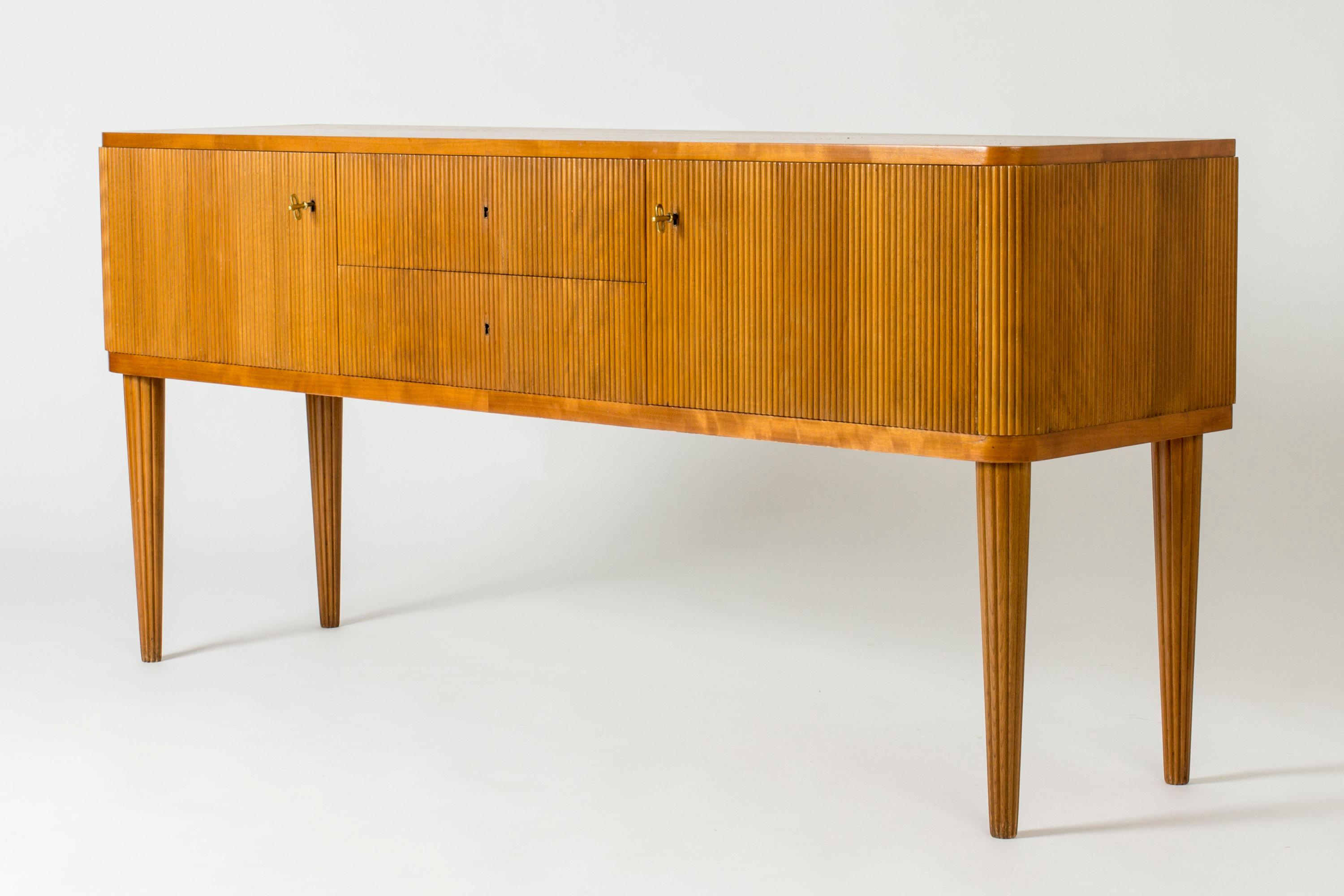 Beautiful Swedish modern sideboard in master carpenter quality, made in the 1940s. Elegant, neat design with an embossed striped pattern on the front and sides. Tapering, striped legs.