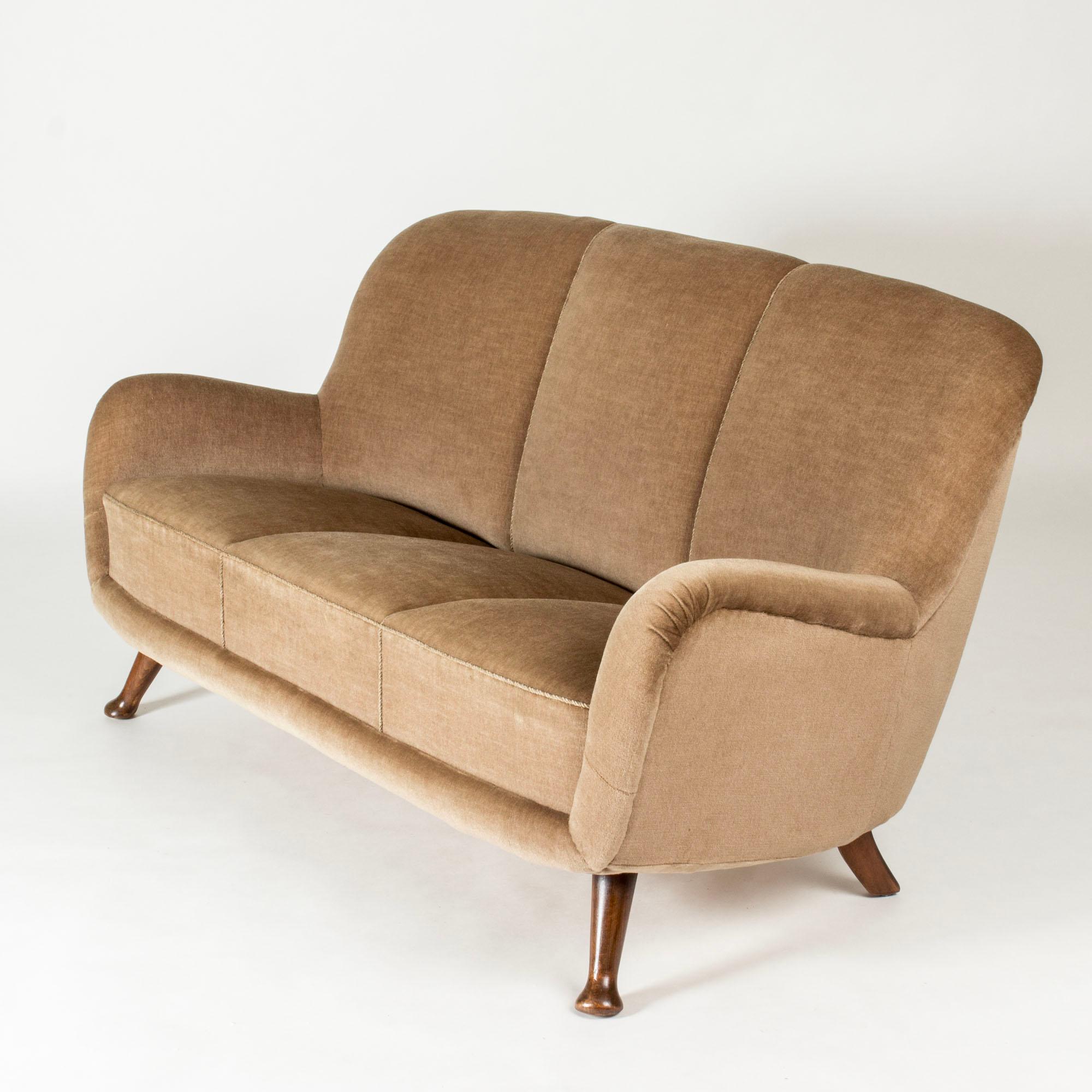 Elegant canapé Swedish Modern de Berga Möbler, aux lignes arrondies et aux pieds sculptés amusants. Garniture d'origine en peluche de couleur taupe.