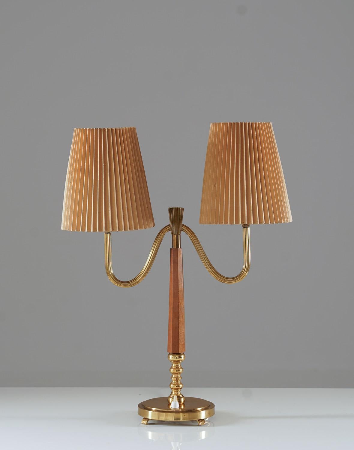 Swedish modern table lamp model 15455 from Böhlmarks Lampfabrik.
This lamp features two light sources, hidden by pleated paper shades that are resting on frosted glass discs. 

Condition: Very good condition. The shades are not original, but is