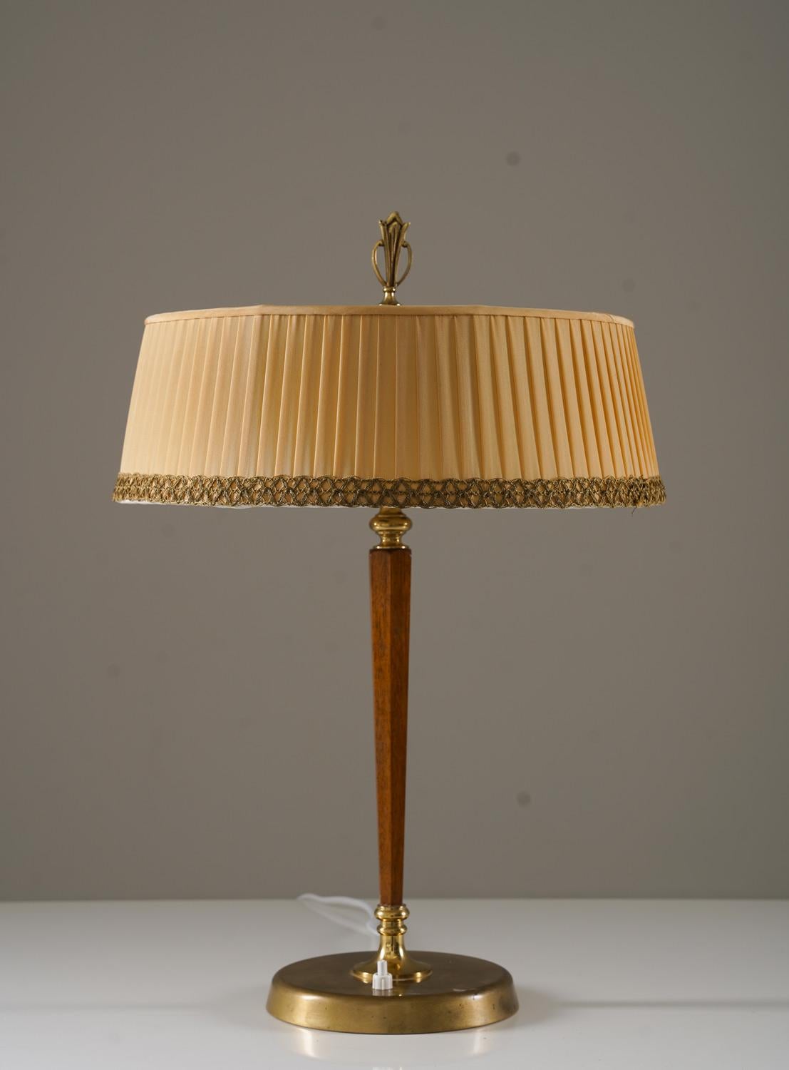 Lámpara de mesa Modelo 2772 de Bröderna Malmbström, Suecia, 1952.
Esta elegante lámpara se fabricó durante la época moderna sueca y es de muy alta calidad.
Consta de una base de latón, que sostiene una barra de caoba con dos fuentes de luz, ocultas