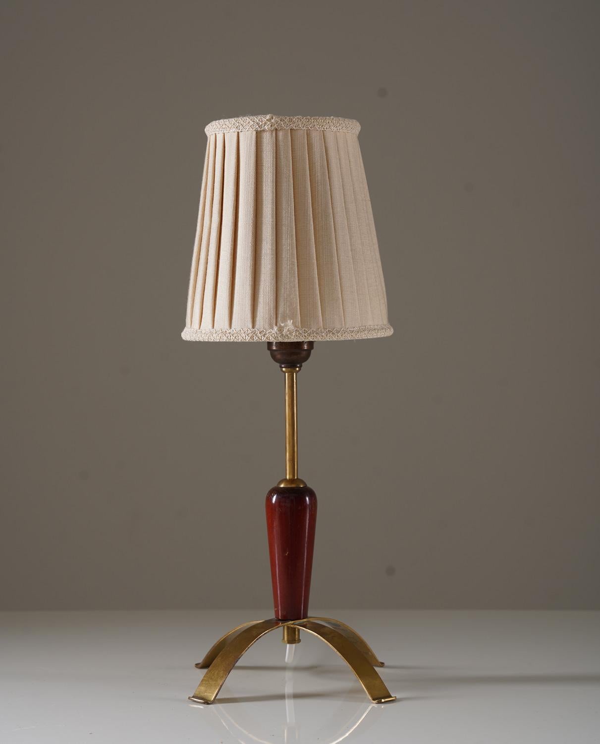 Swedish modern table lamp by AB E.Hansson, Sweden.
This lamp consist of a brass base and rod with wooden details and a pleated fabric shade

Condition: Very good condition. 